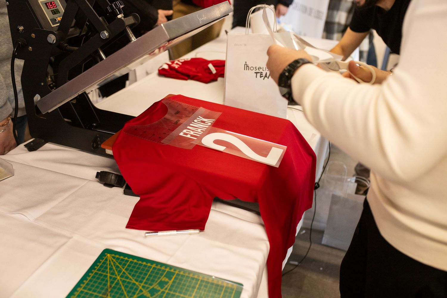 Maillot rouge pressé à chaud avec le numéro 2 et le texte français sur la machine d'impression.
