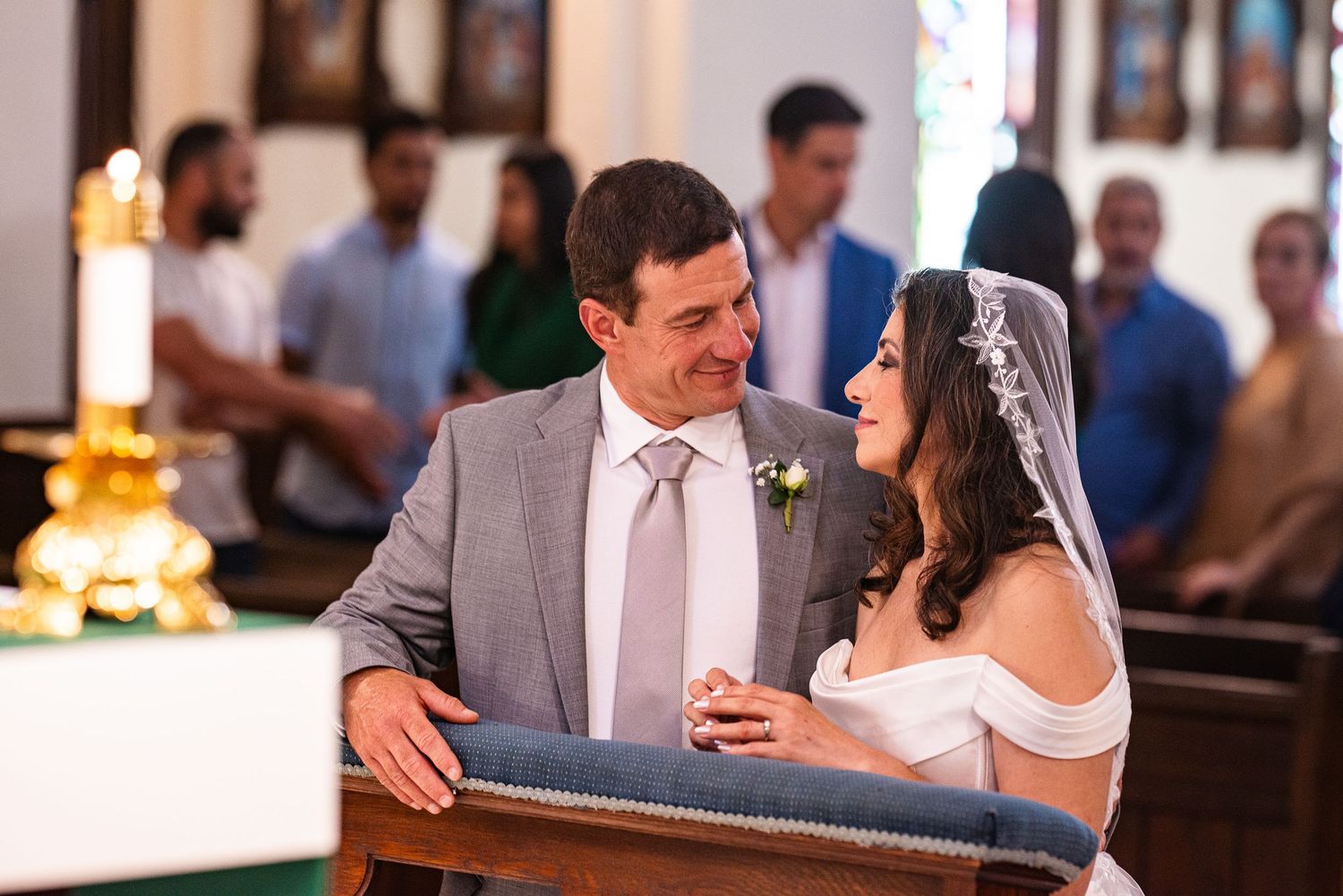 Bride and groom share a joyful moment at the church altar during their wedding ceremony.