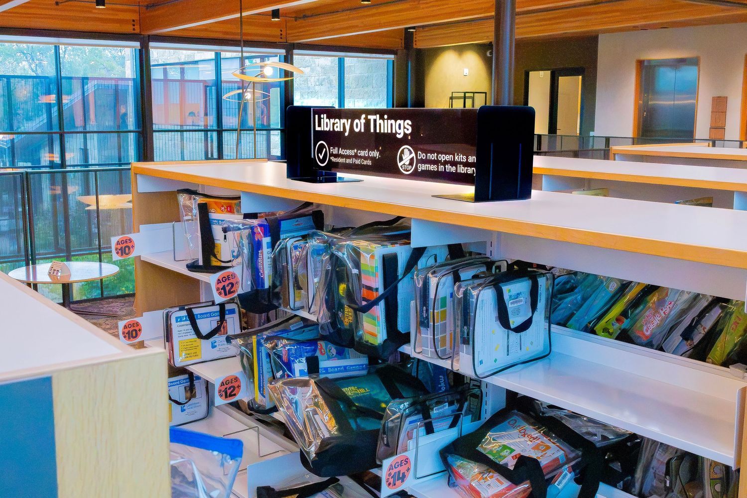 Library of Things section with colorful tote bags on shelves in a modern public library.