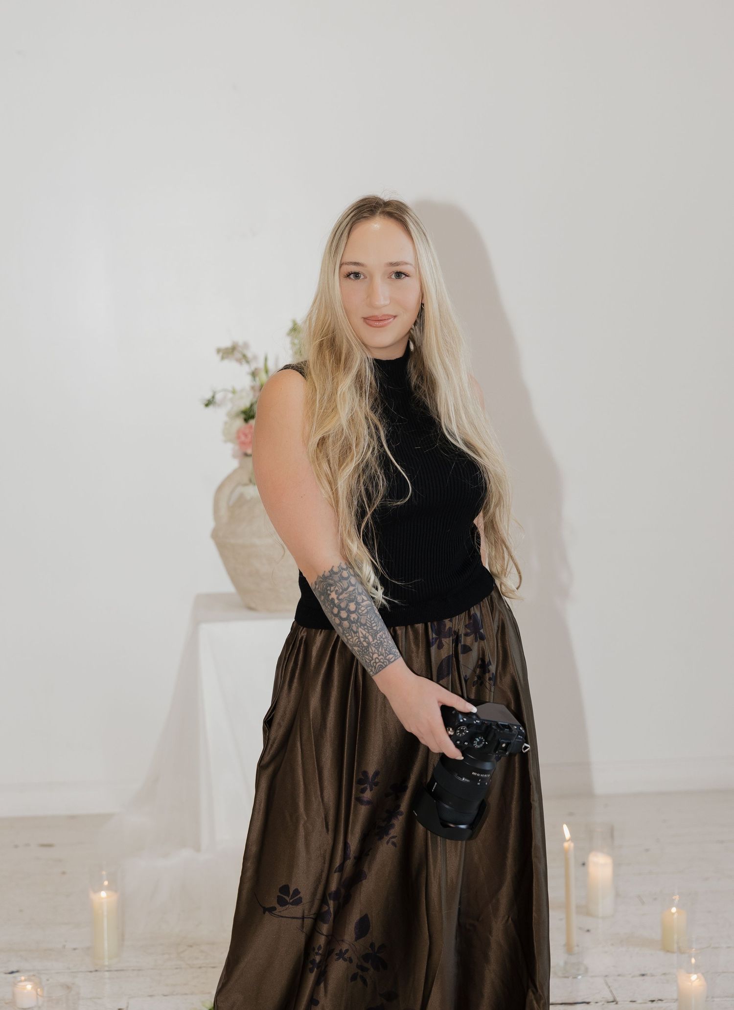 A series of fashion photos featuring a black sleeveless top and brown skirt ensemble against a white backdrop with candles.