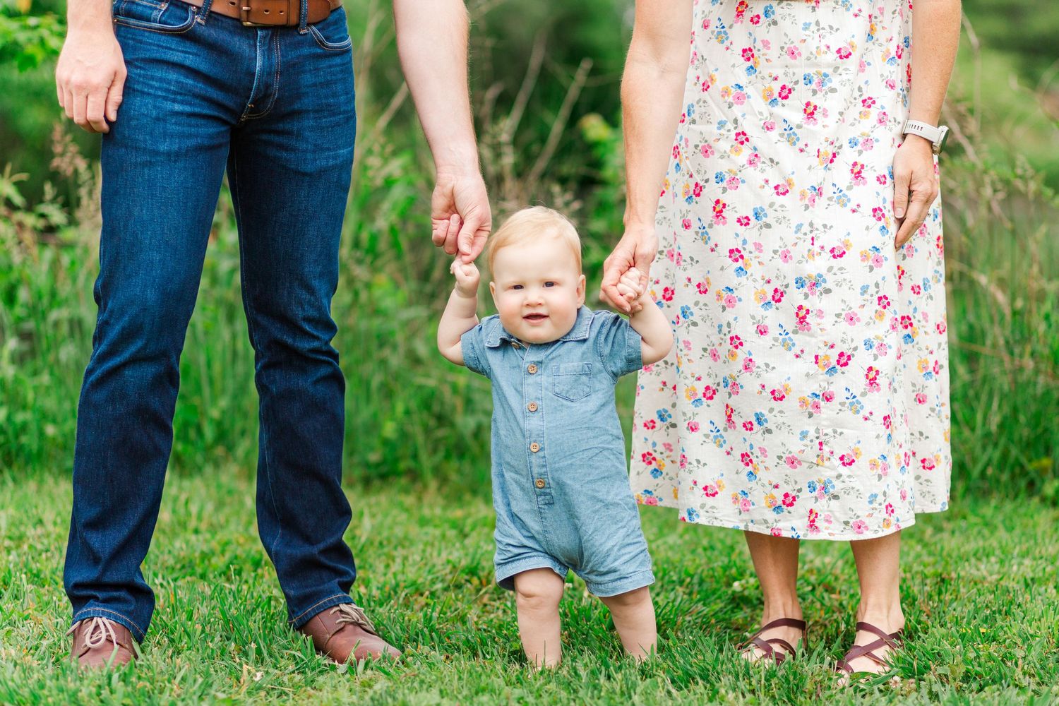 A family wearing floral dresses and denim outfits walks pose for family photos in Hendersonville, NC taken by a Clemson, SC photographer