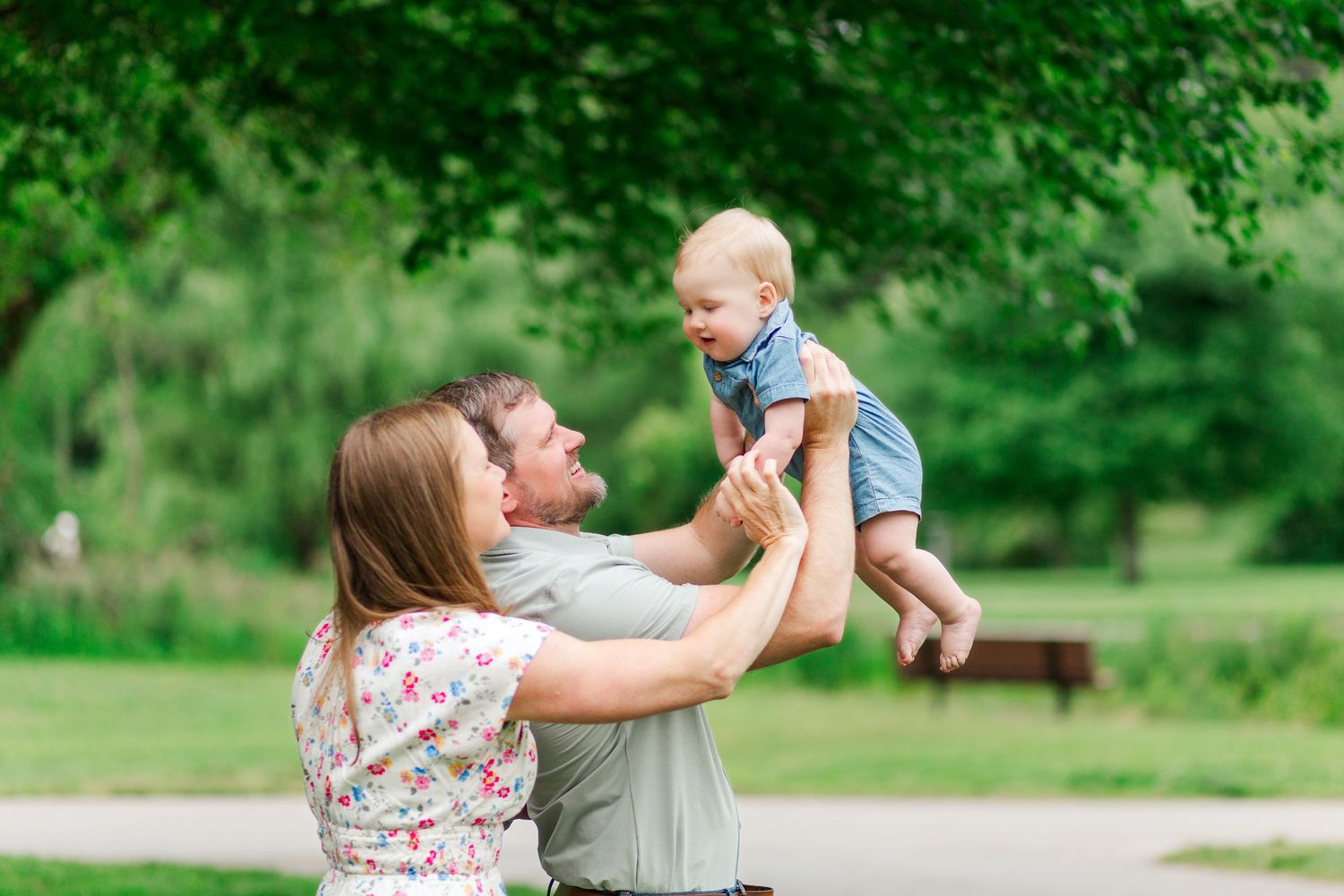 Family enjoys joyful moments together in a lush green park setting in Hendersonville, NC taken by a Clemson, SC photographer