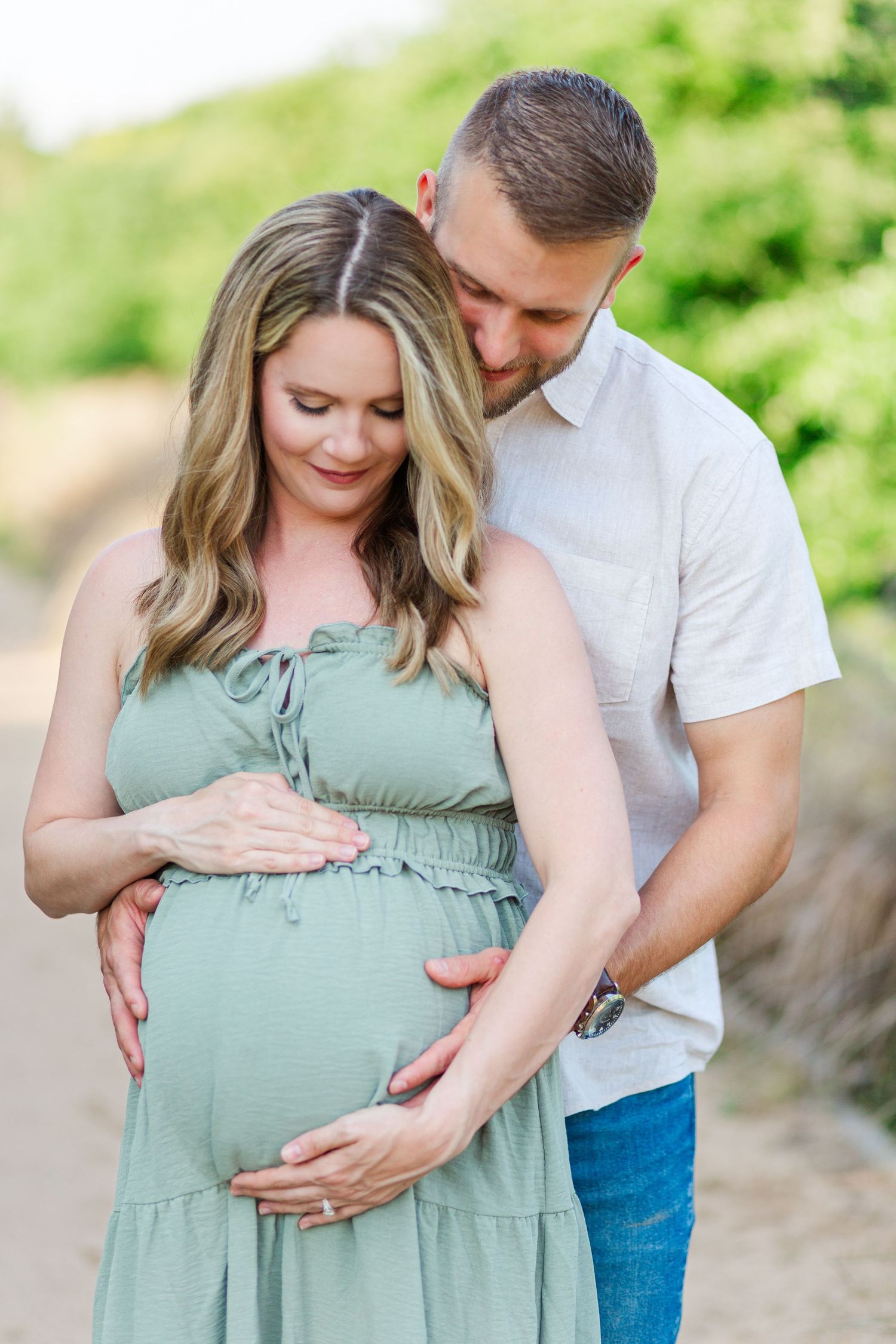 A couple shares an intimate moment outdoors as they lovingly embrace for a maternity photo session in Clemson, SC