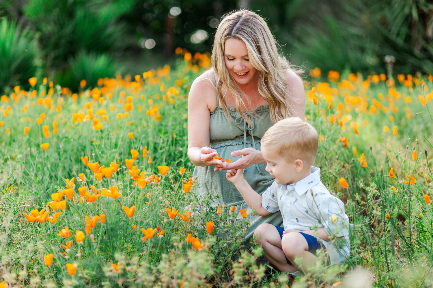 A parent and child share a tender moment among vibrant yellow wildflowers in a lush green meadow.
