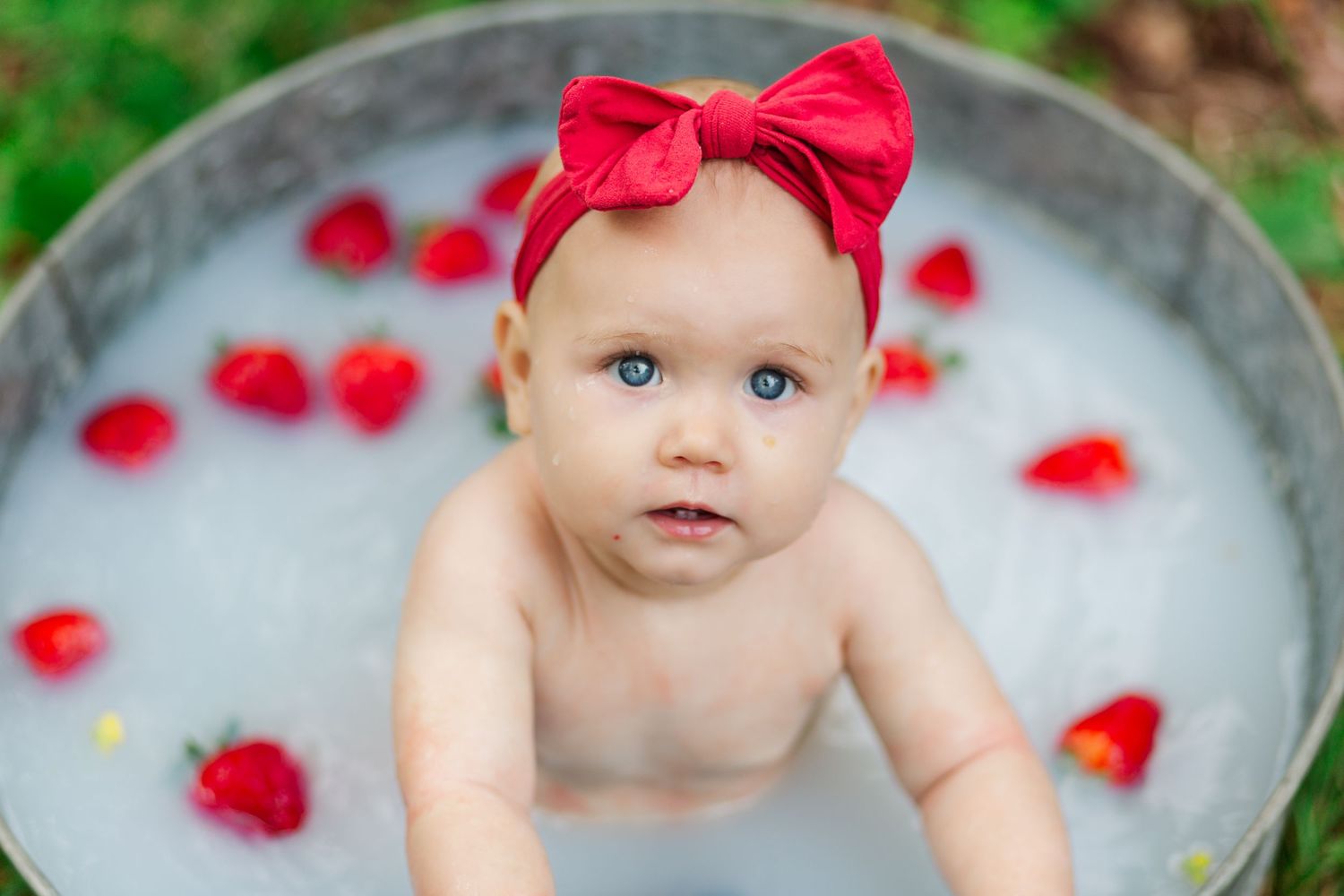Small baby wearing red bow headband in Greenville, SC for a milestone session