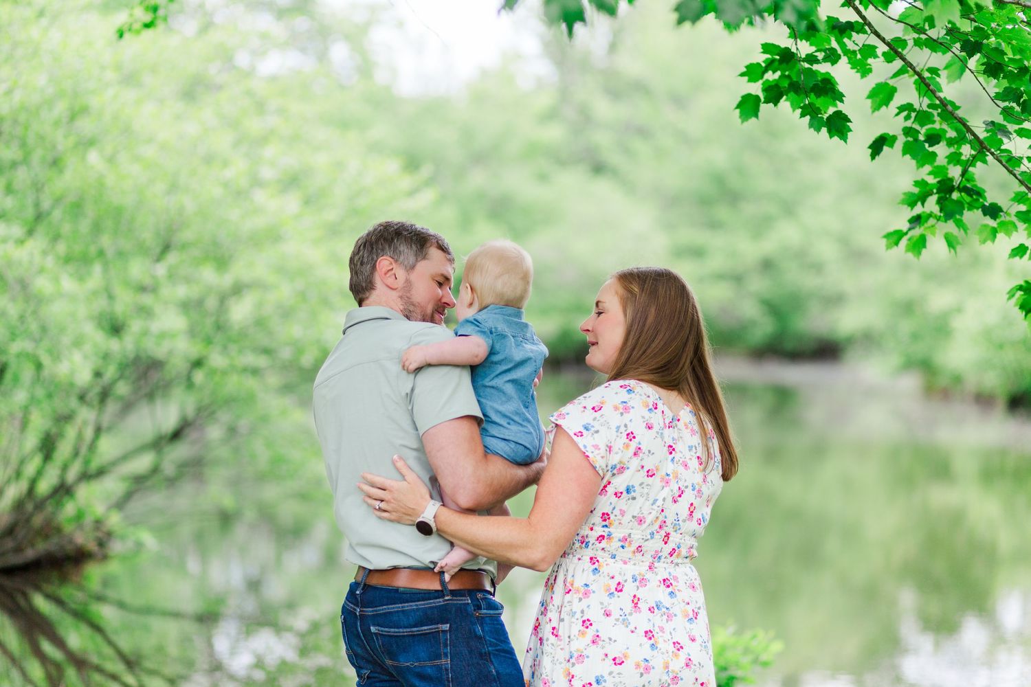 Family sharing tender moments together by a tranquil pond near Pickens, SC for family photos