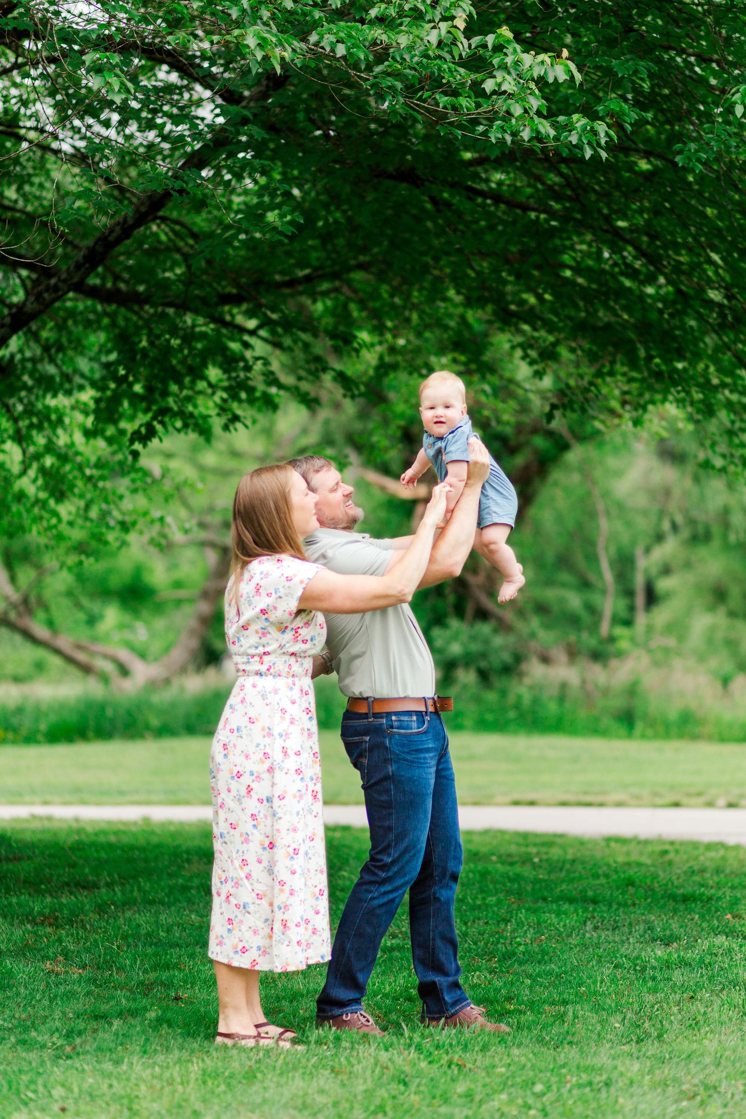 Happy family plays together on for a family photo session in Hendersonville, NC taken by a Clemson, SC photographer