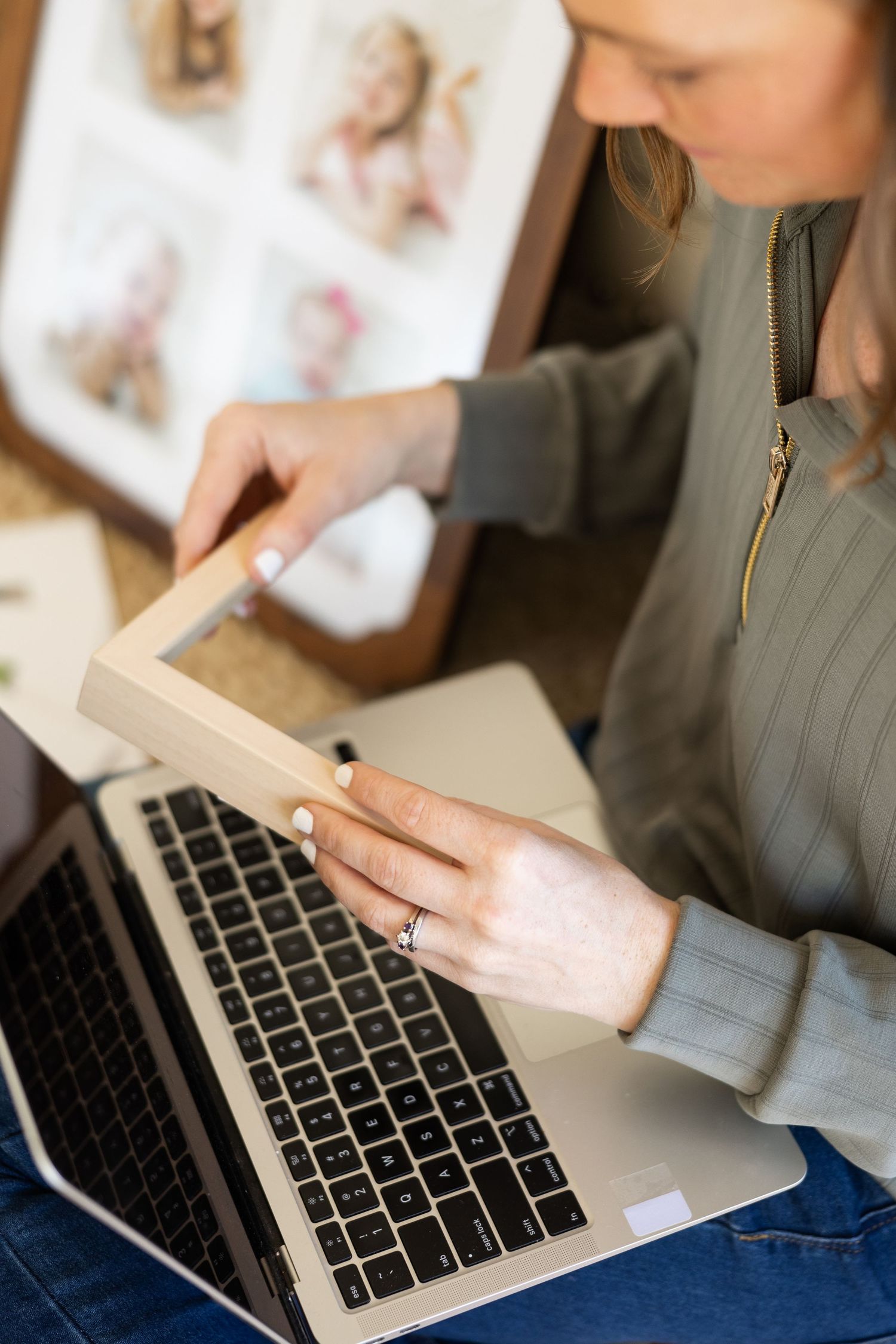Person working on laptop while holding smartphone showing multitasking in modern workspace setting.