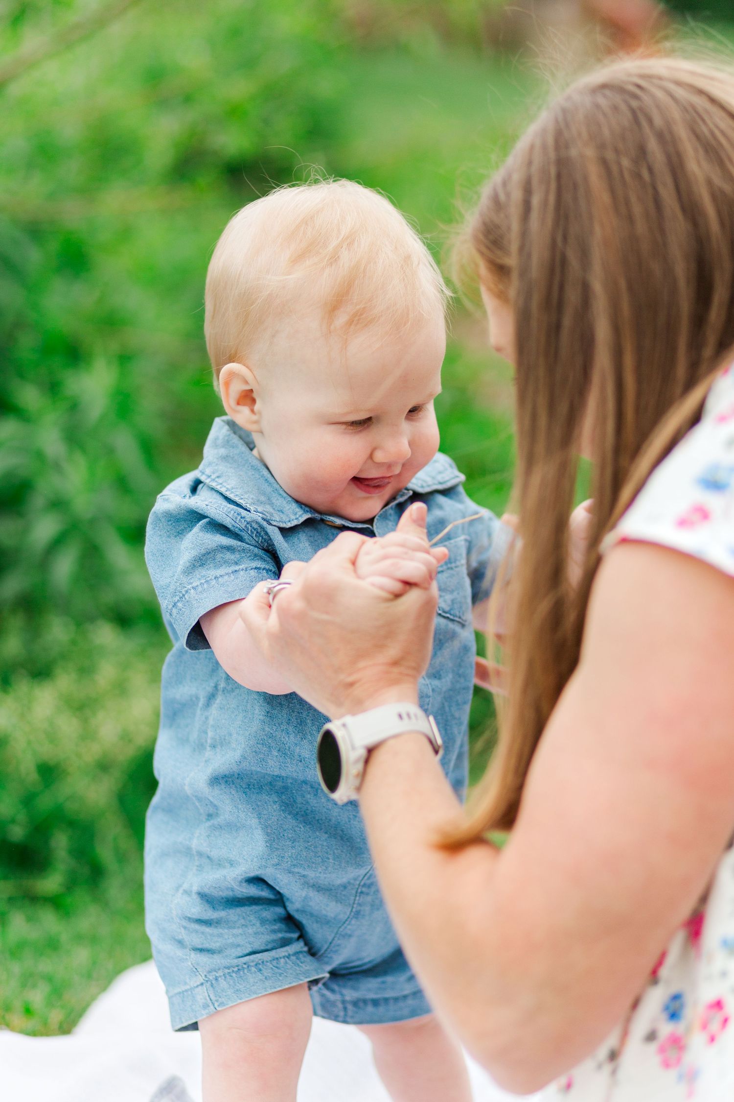 A baby in denim outfit giggles for a photo in Hendersonville, NC taken by a Clemson, SC photographer
