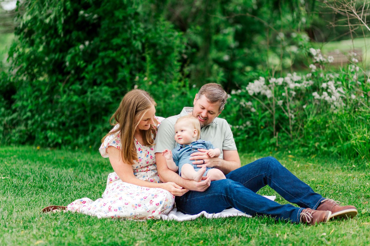 Family relaxes together on blanket for a photo session in Hendersonville, NC taken by a Clemson, SC photographer