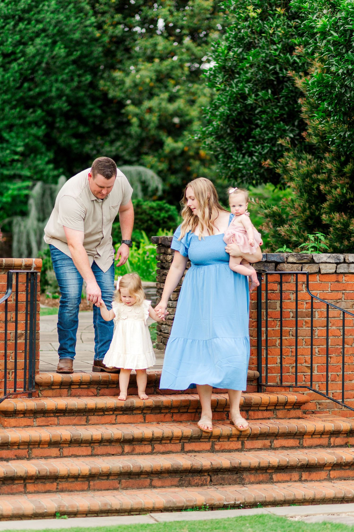 A family walking down a curved brick wall for family photos in Clemson, SC