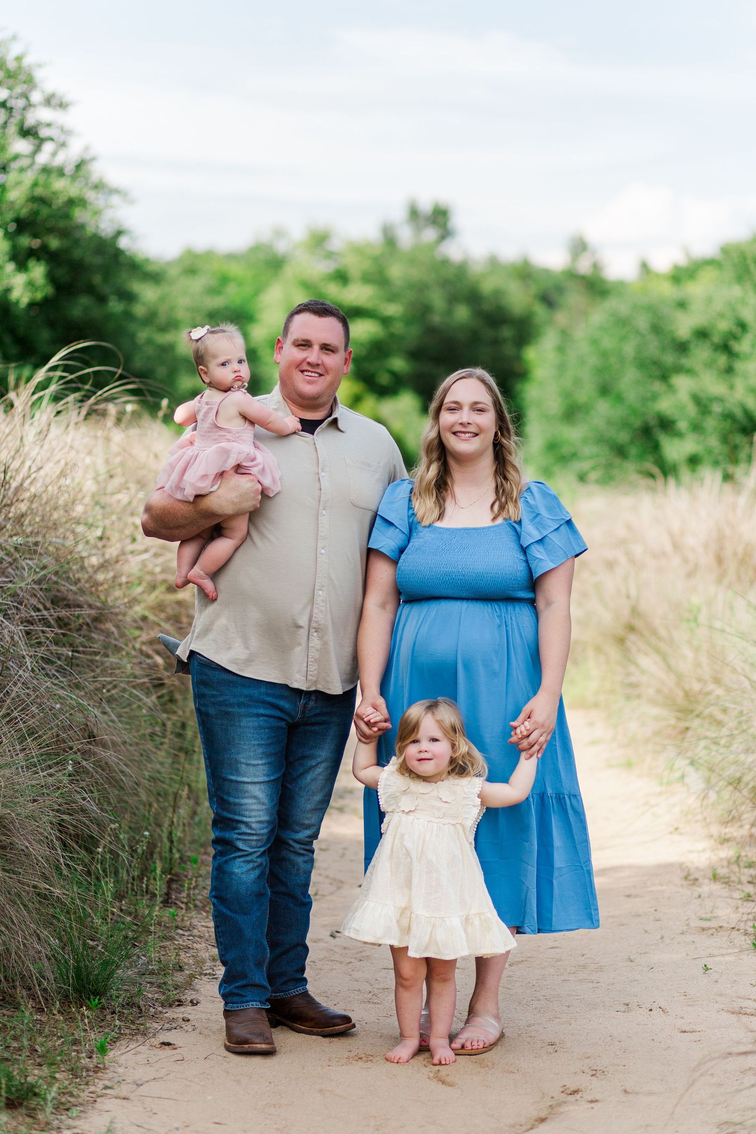 Family walking together on a dirt path for spring family photo session in Clemson, SC