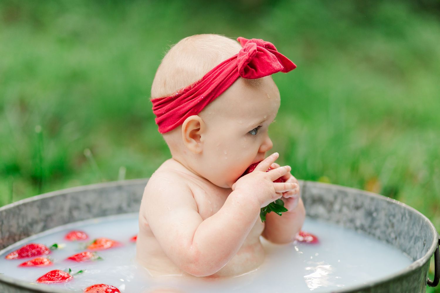 A baby splashes and plays in Greenville, SC for a one year milestone session