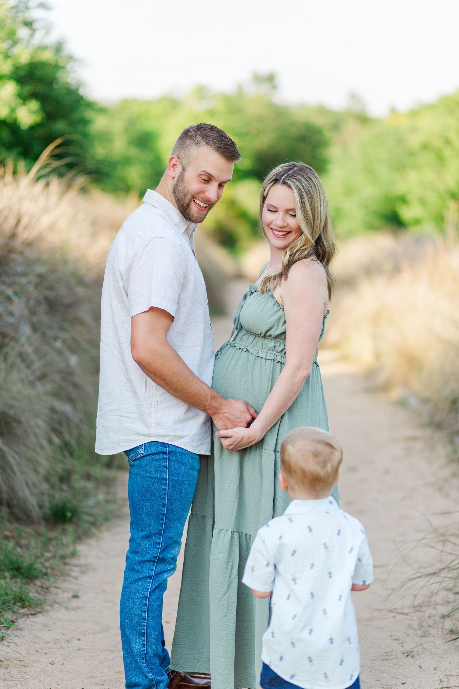 Family maternity photo shoot on a nature trail with soft lighting and sage green dress at the Botanical Gardens in Clemson, SC