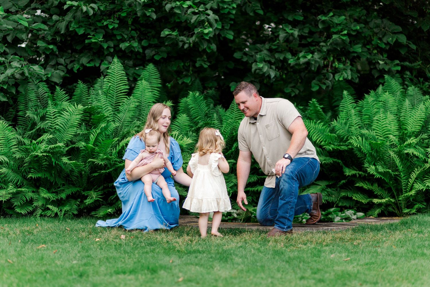 Family photo session on grass with lush greenery backdrop at the Botanical Gardens in Clemson, SC