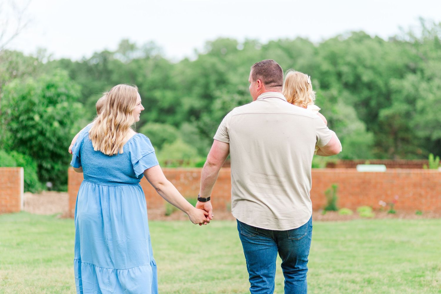 A family walking through a grassy field for family photos in Clemson, SC