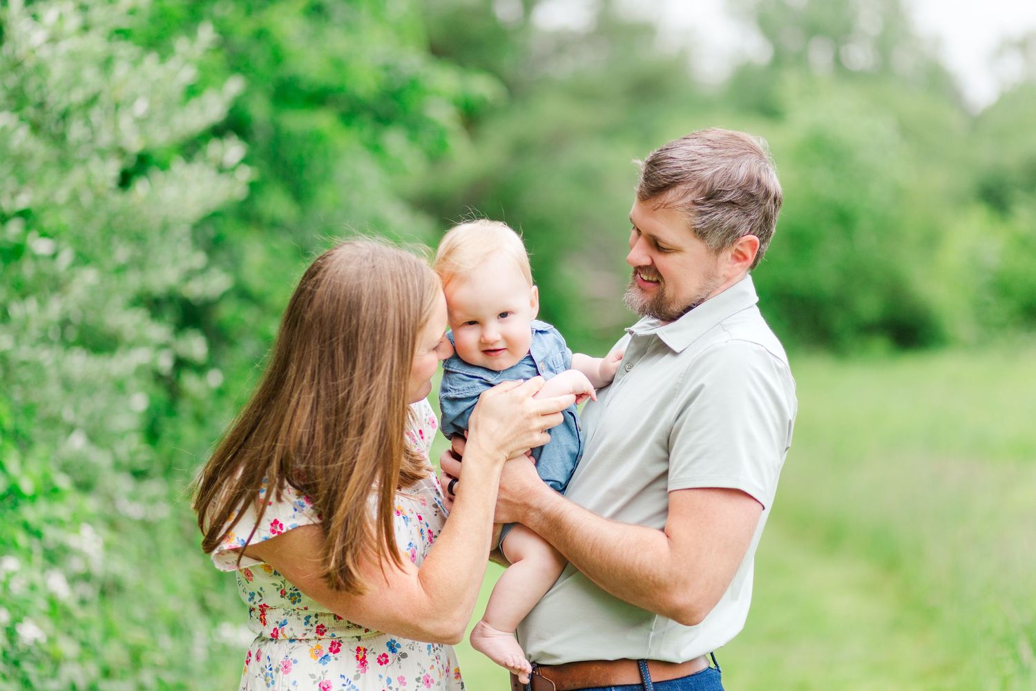 A loving family moment captured in a series of candid outdoor photos on a lush green spring day in Hendersonville, NC taken by a Clemson, SC