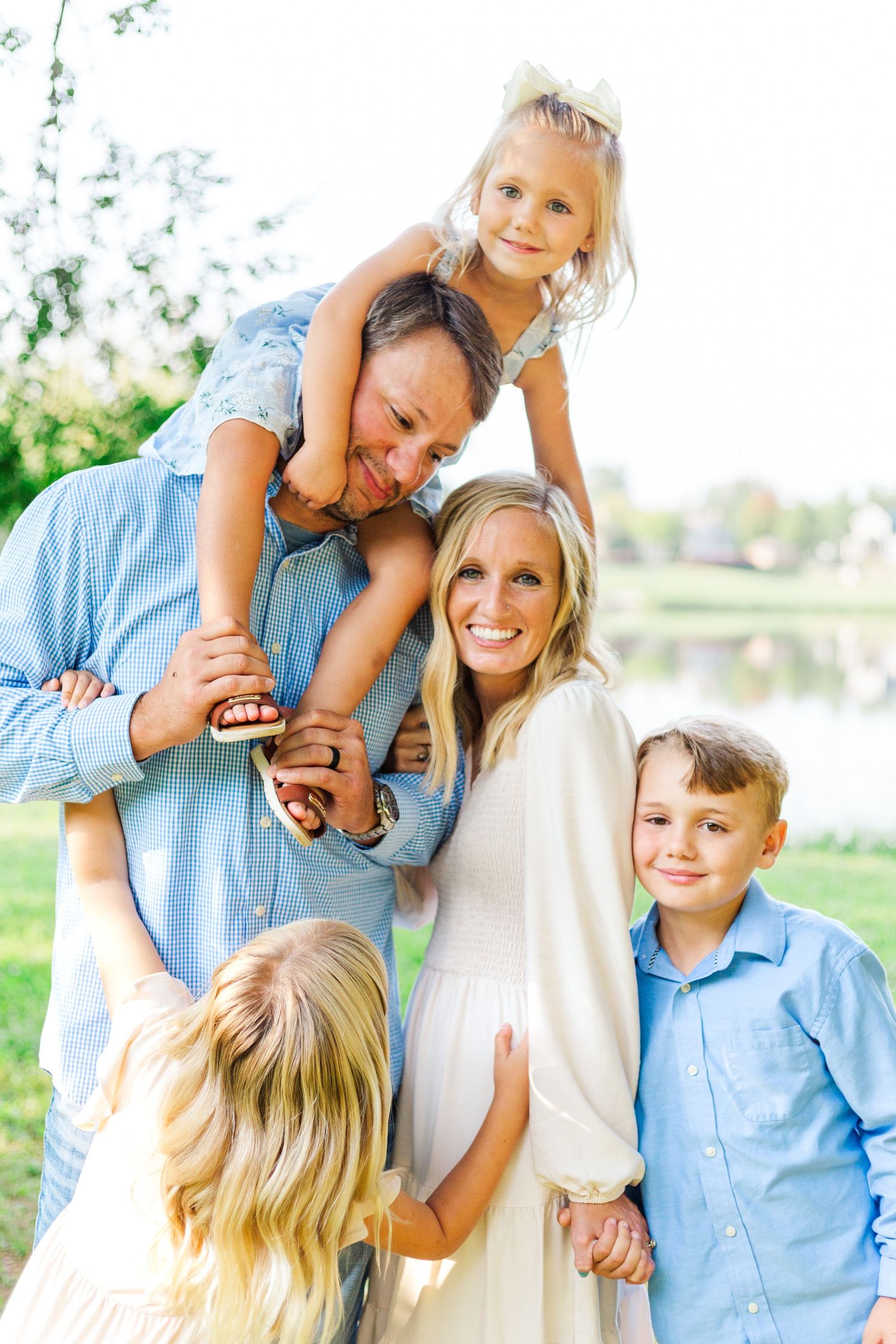 A family in coordinating blue and white outfits poses playfully together outdoors in Clemson, SC
