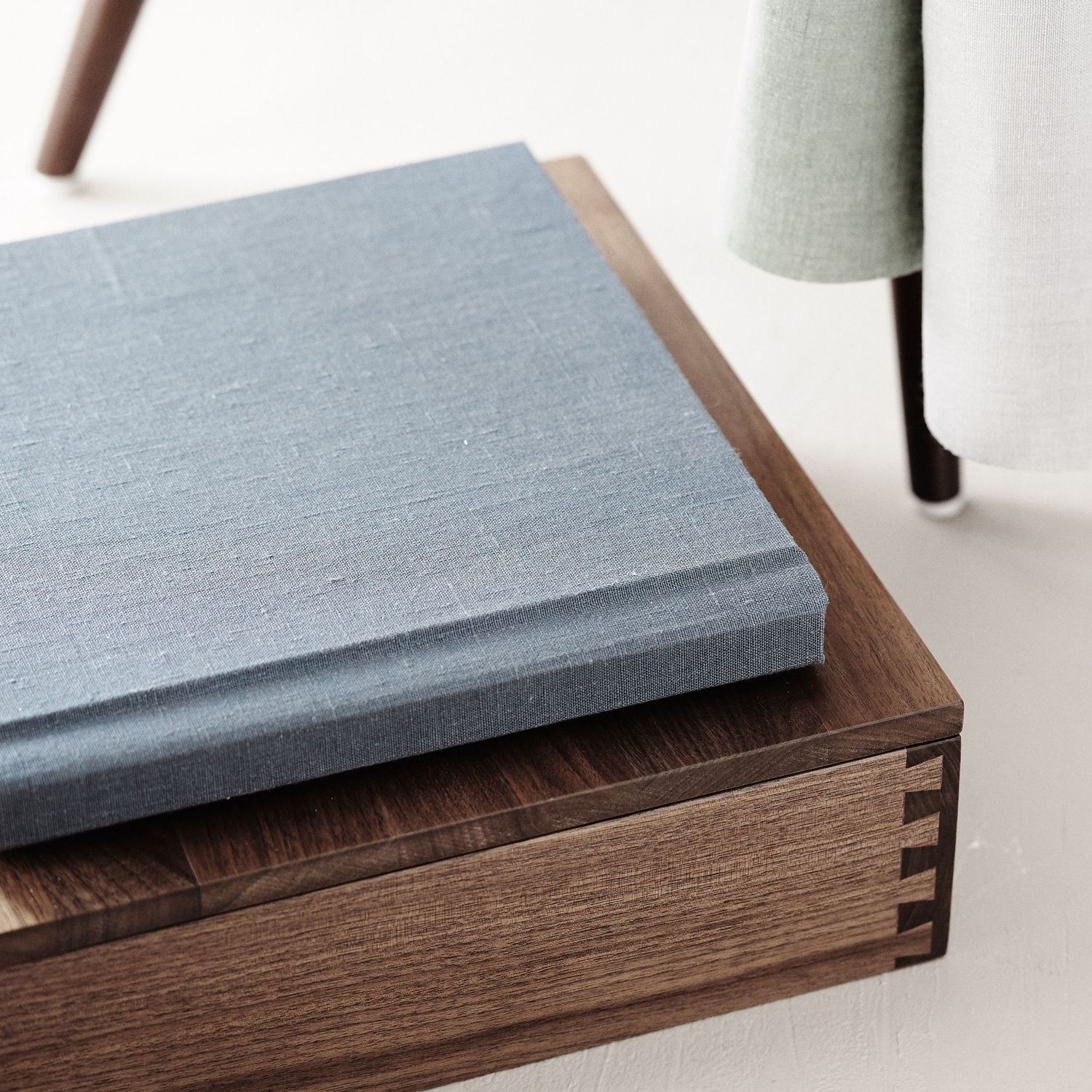 A wooden box with a light gray textured lid shown in a progressive sequence of closing positions.