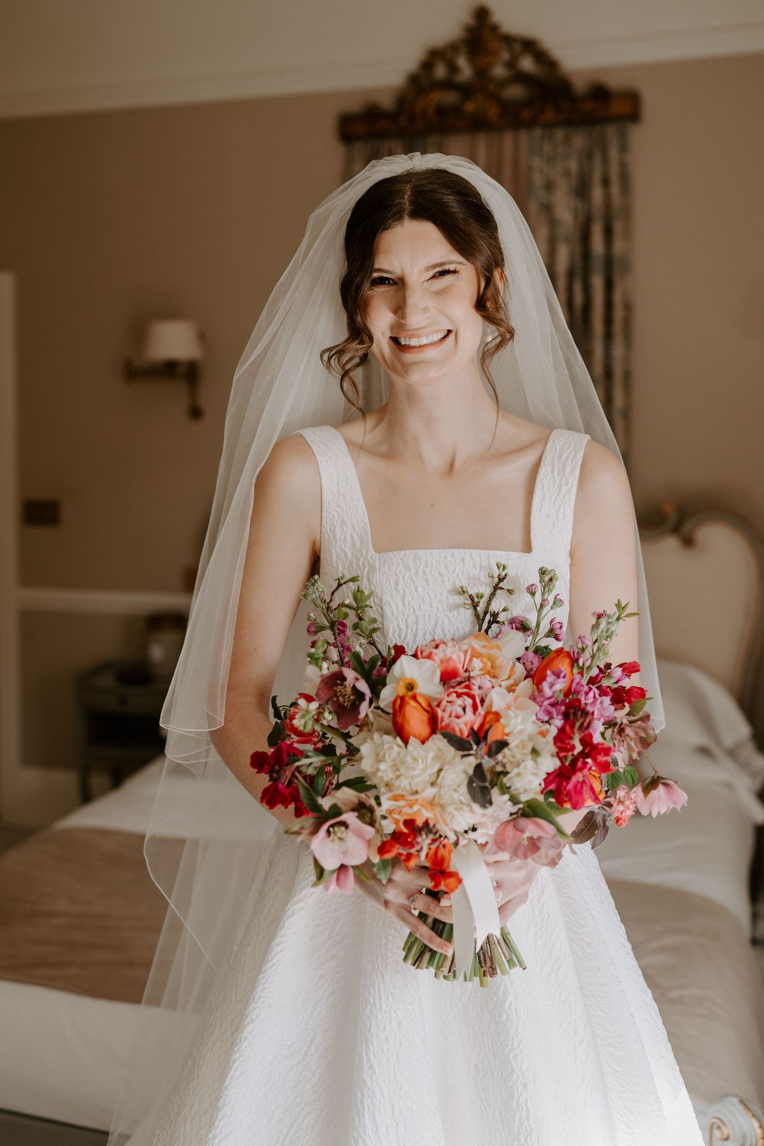 A bride with soft glam make up and soft curls in the front of her hair.