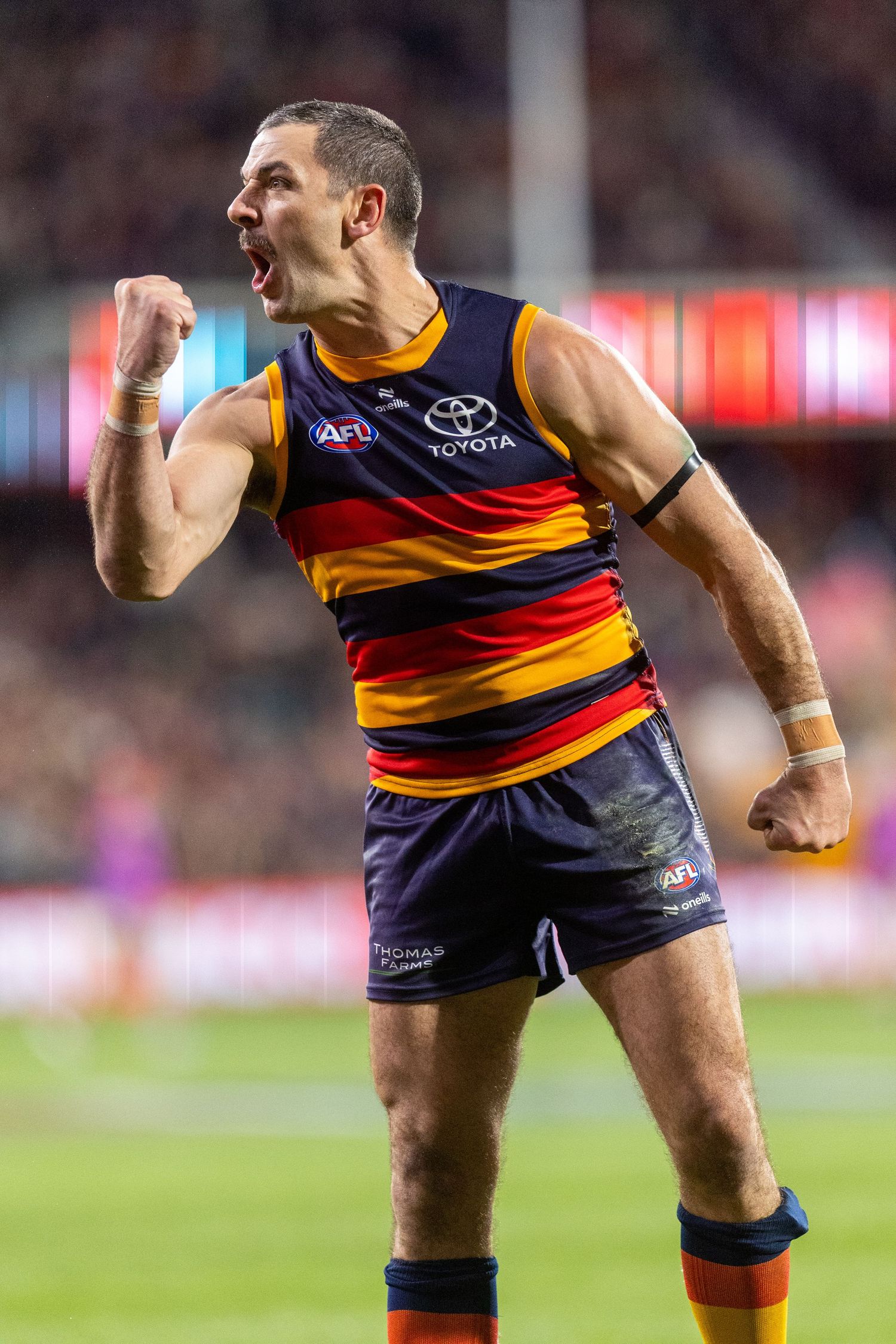 AFL player in striped jersey making athletic move during game.