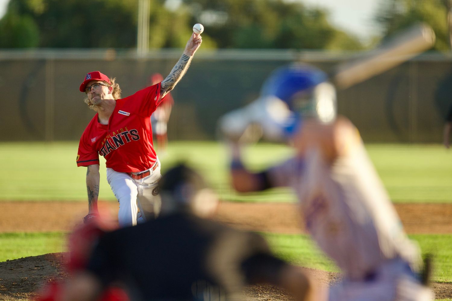 Baseball players warming up on a sunny field before a game.