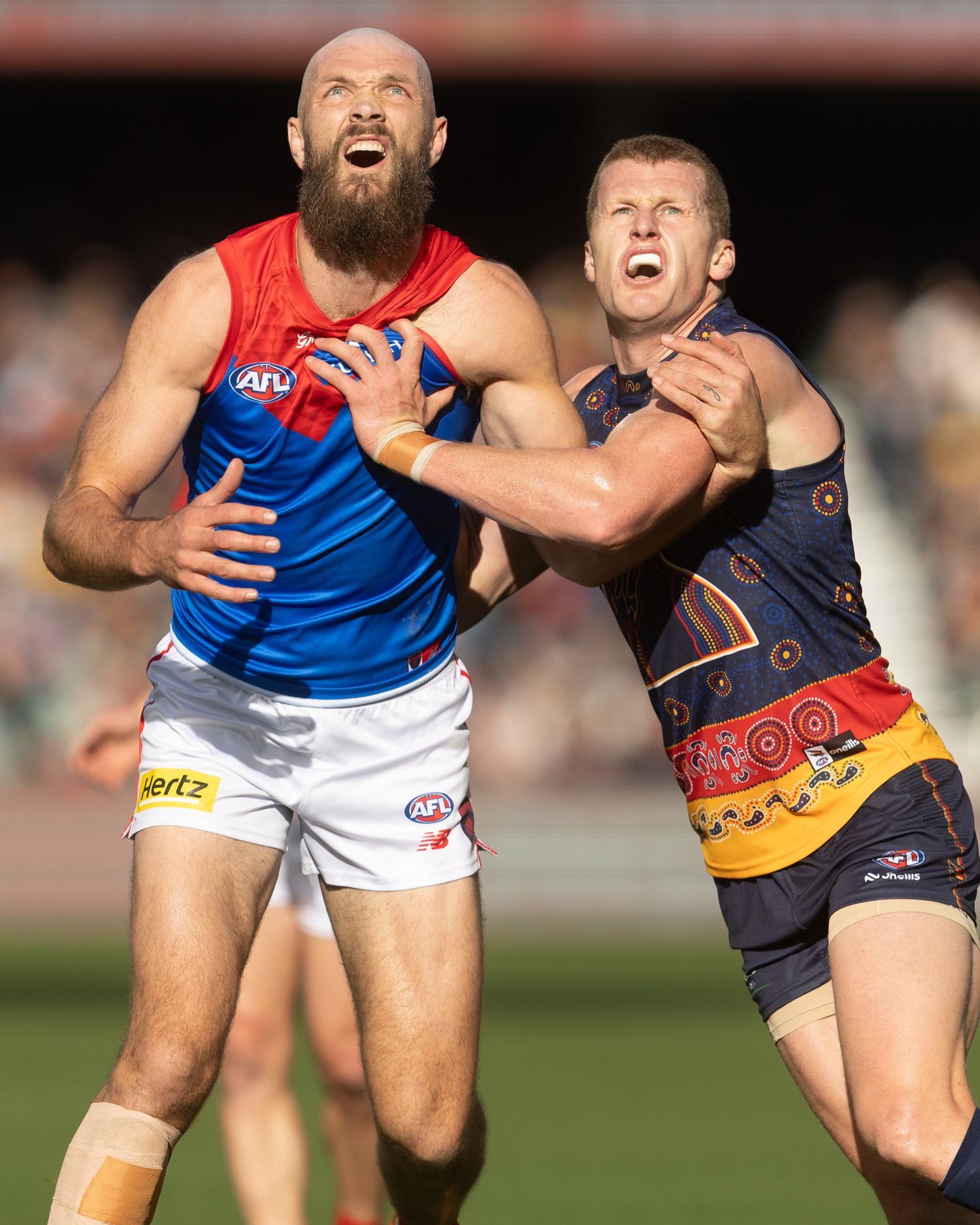 Australian football players compete for possession during an intense AFL match.
