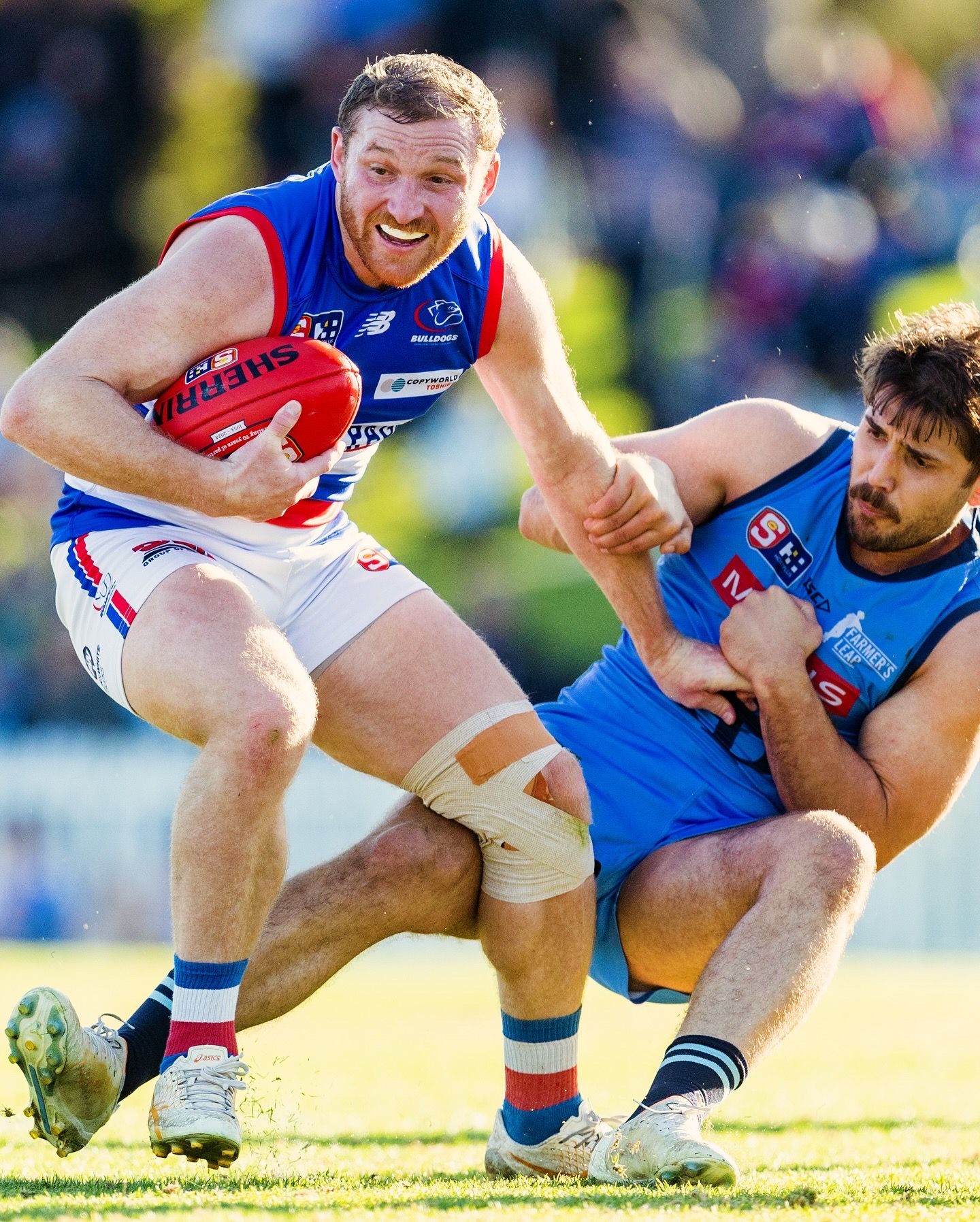 Australian football players battle for possession during intense match action.