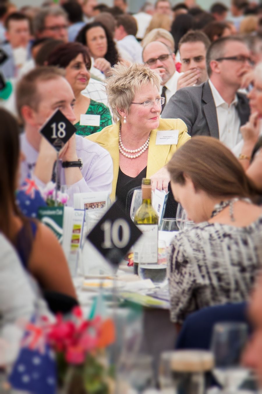 Large group of conference attendees seated at tables during a business event.