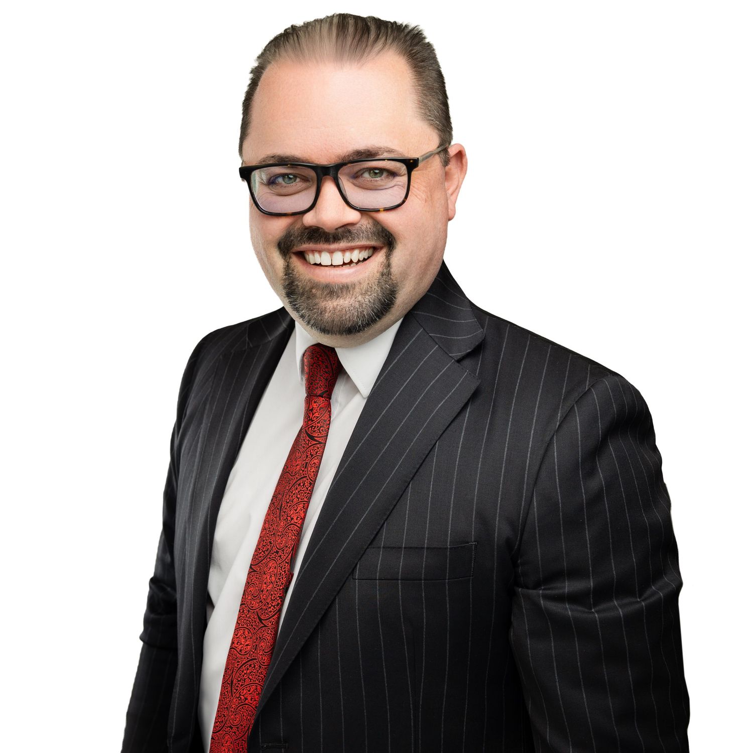 Business portrait series of person in pinstripe suit and red tie against white backdrop.