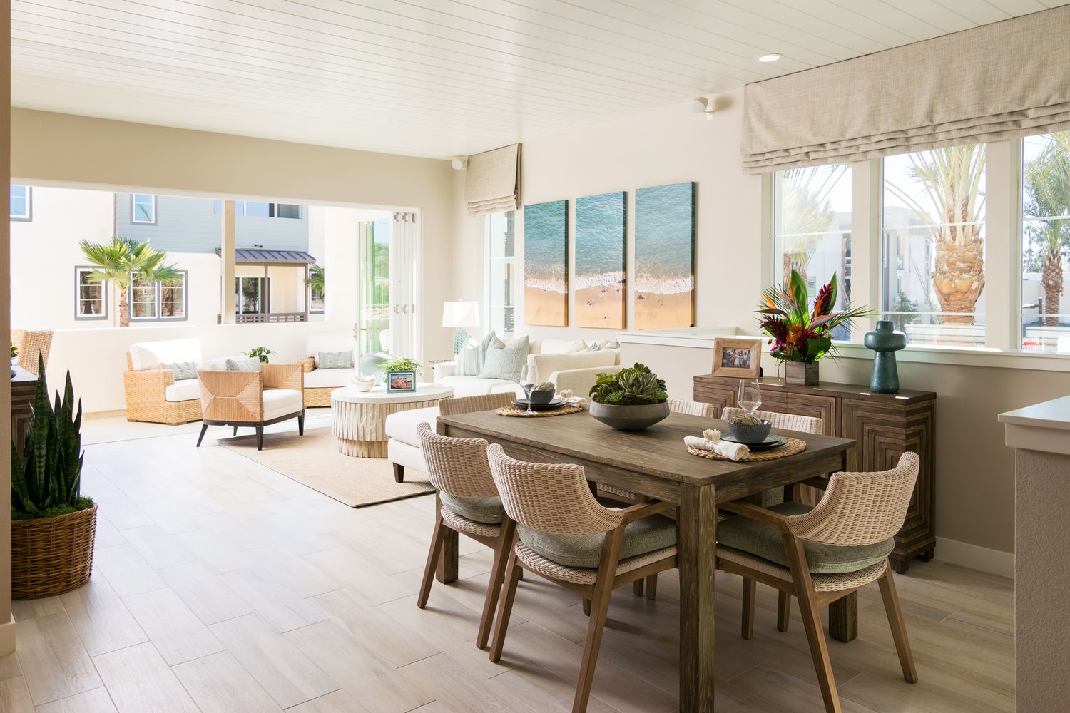 Bright open concept living and dining area with hardwood floors, neutral decor and coastal-inspired furnishings.