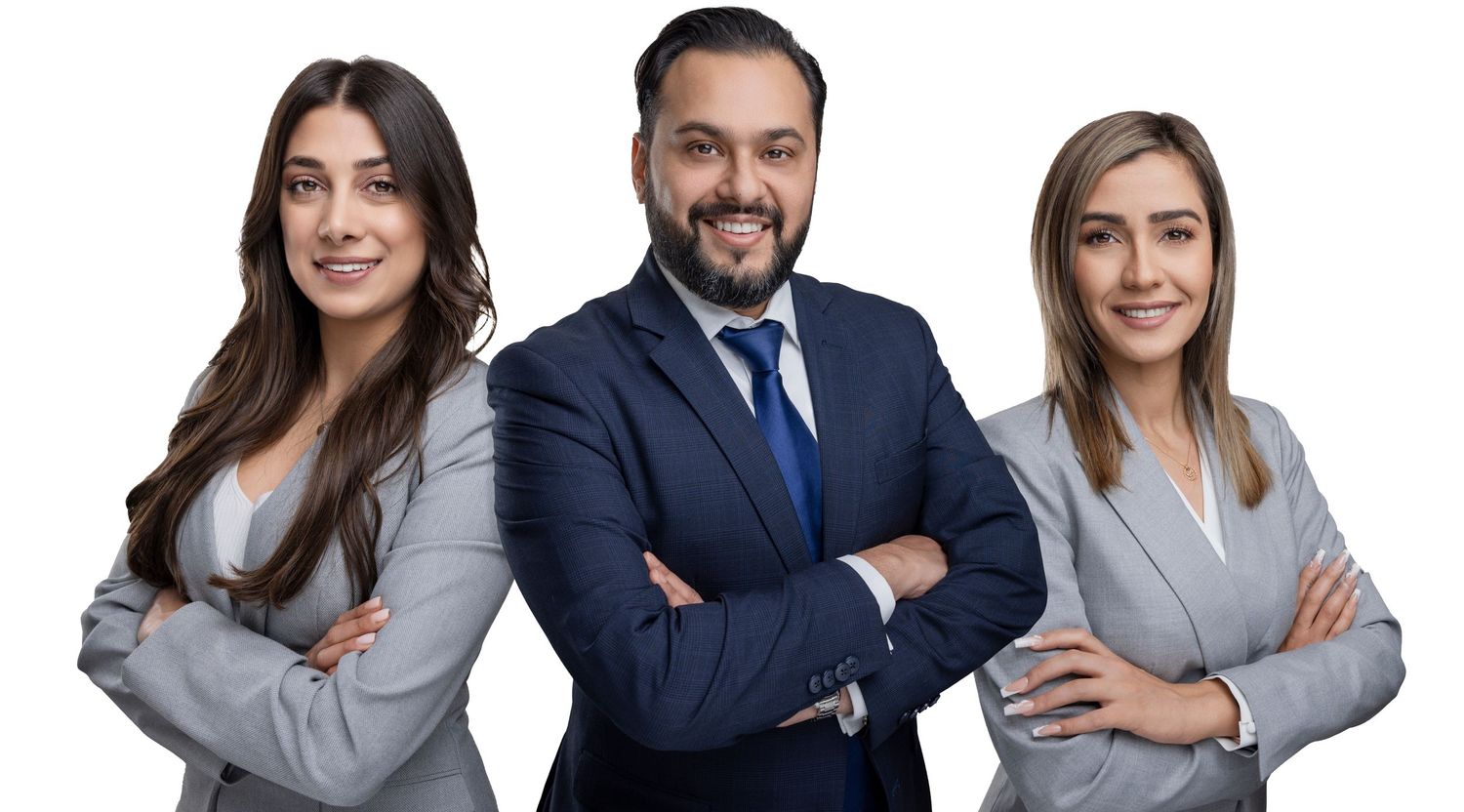 Professional business team in suits posing together against a light background.