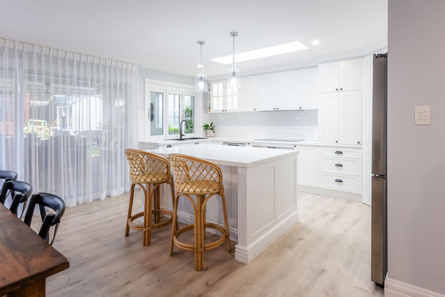 Modern minimalist interior design featuring light wood floors and white walls with natural lighting.