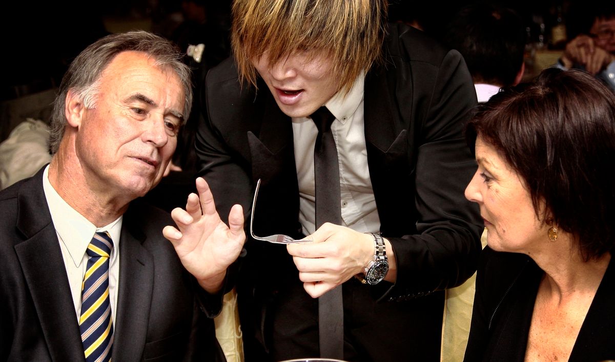 Business professionals in formal attire engaged in conversation at a networking event.