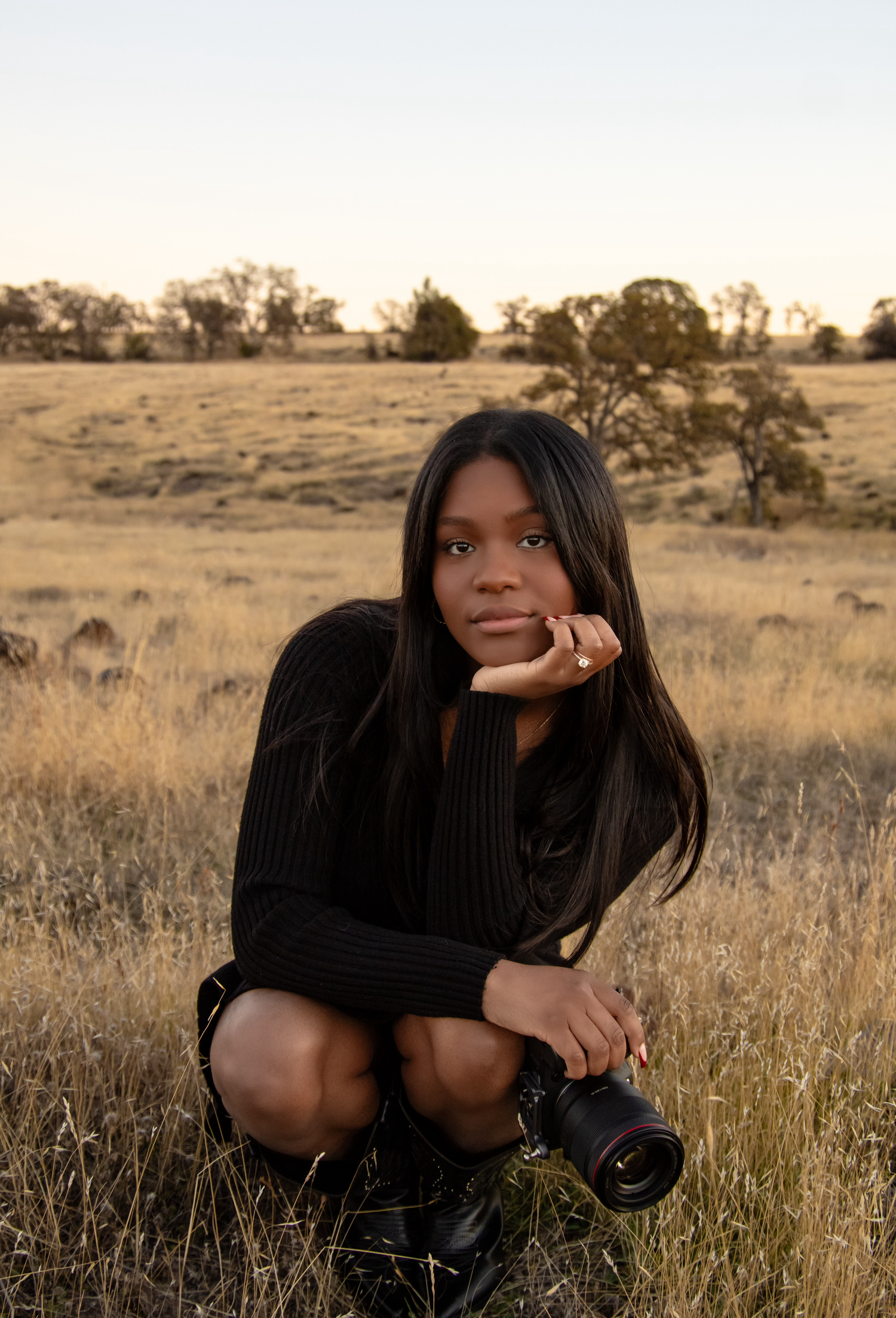 Artistic portrait session in golden grass field during sunset.