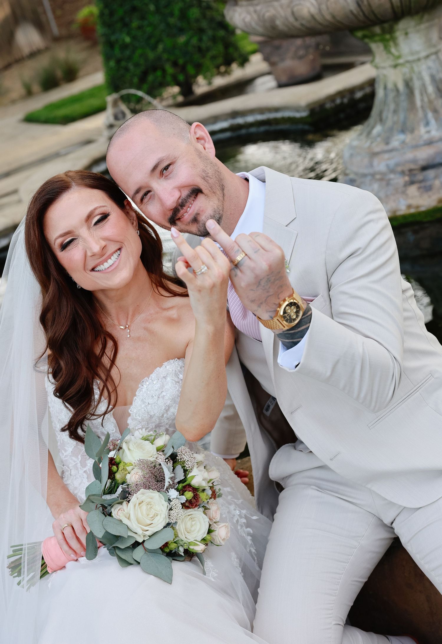 A happy couple in wedding attire share joyful moments together while posing for outdoor photos.