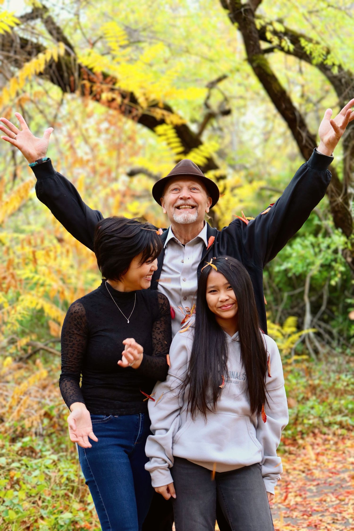 Energetic family photos with autumn foliage and yellow leaves in background.