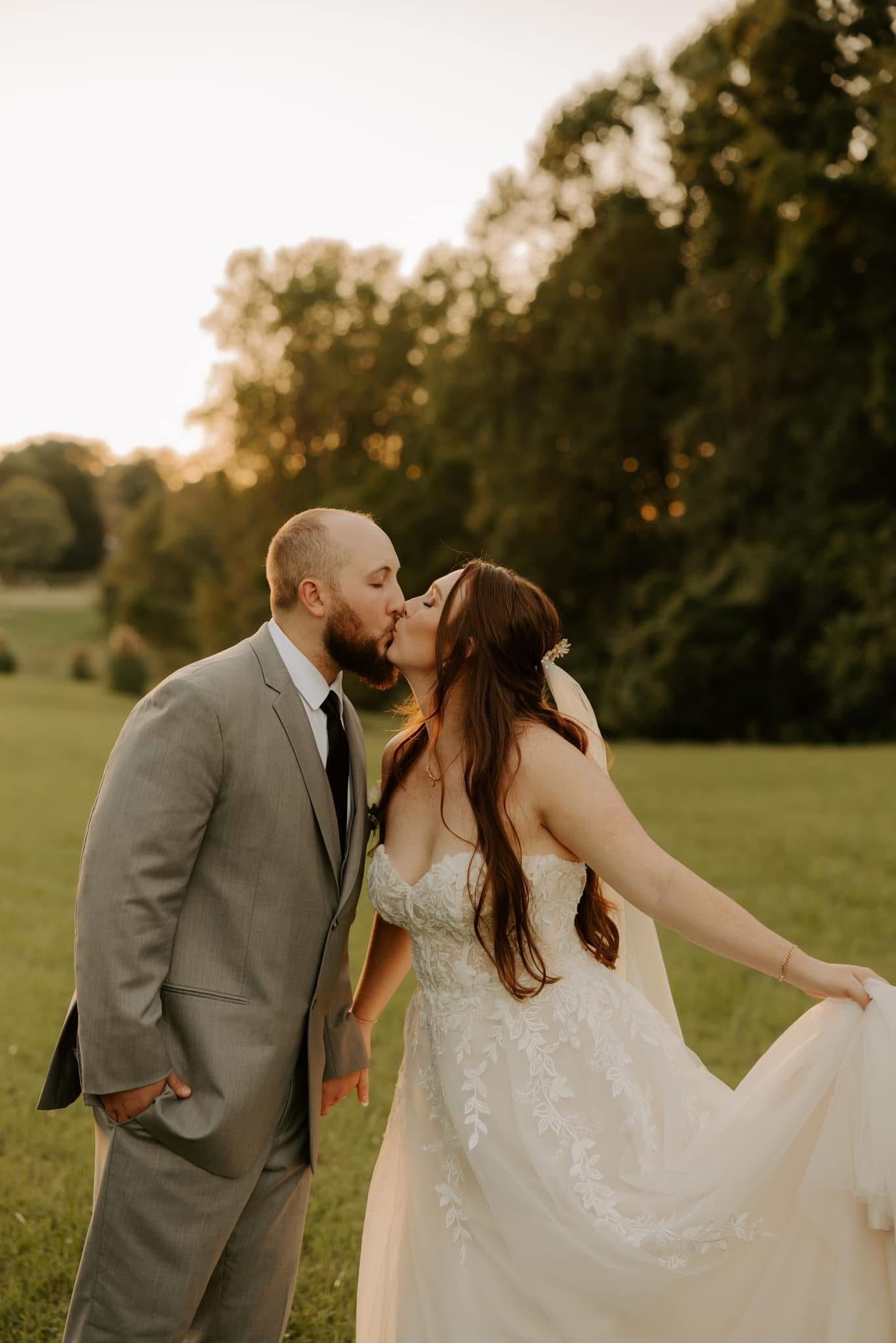 Romantic sunset wedding portraits in a grassy field with golden light.