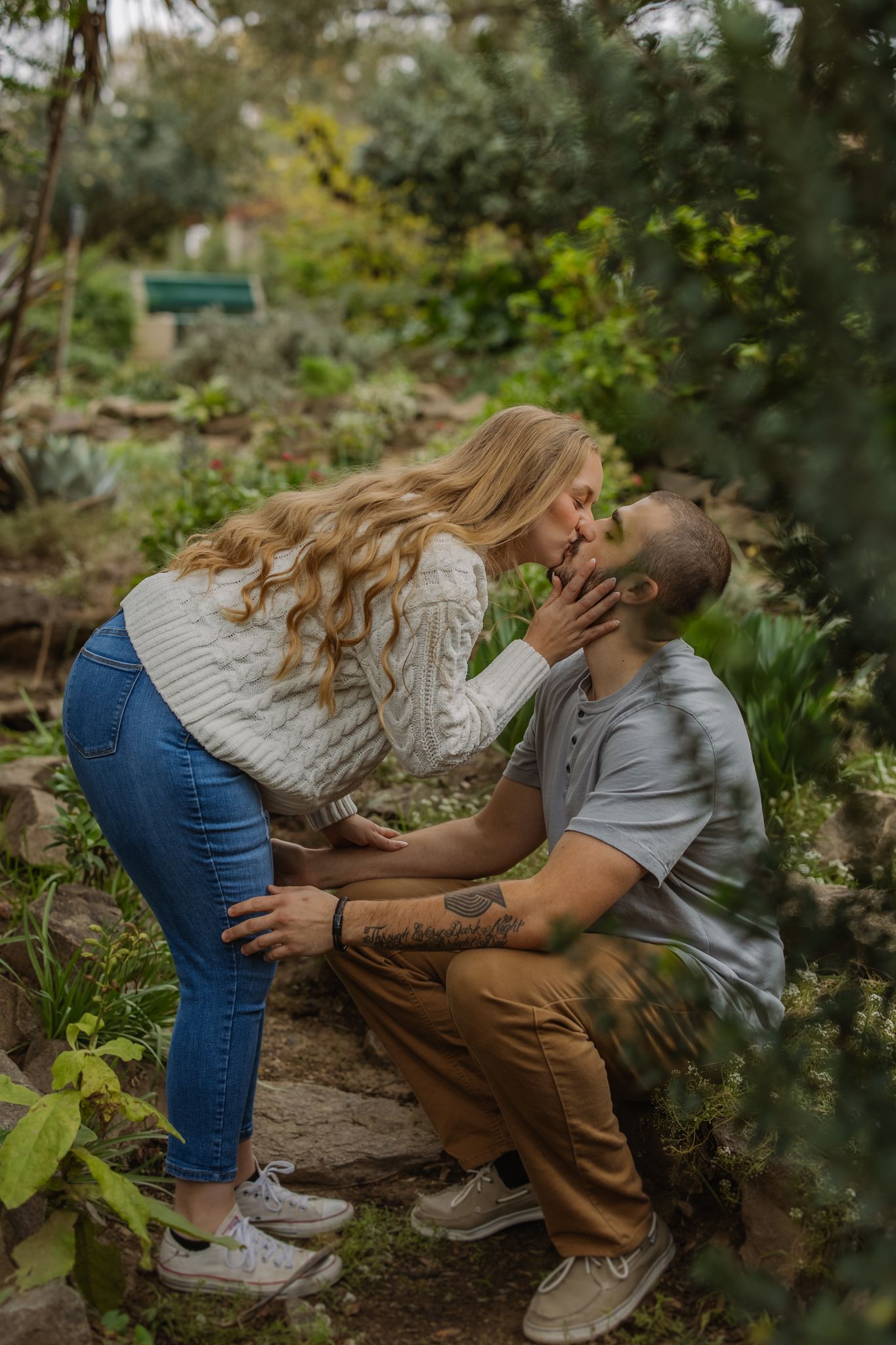 Intimate outdoor photoshoot among green foliage showing tender moments.