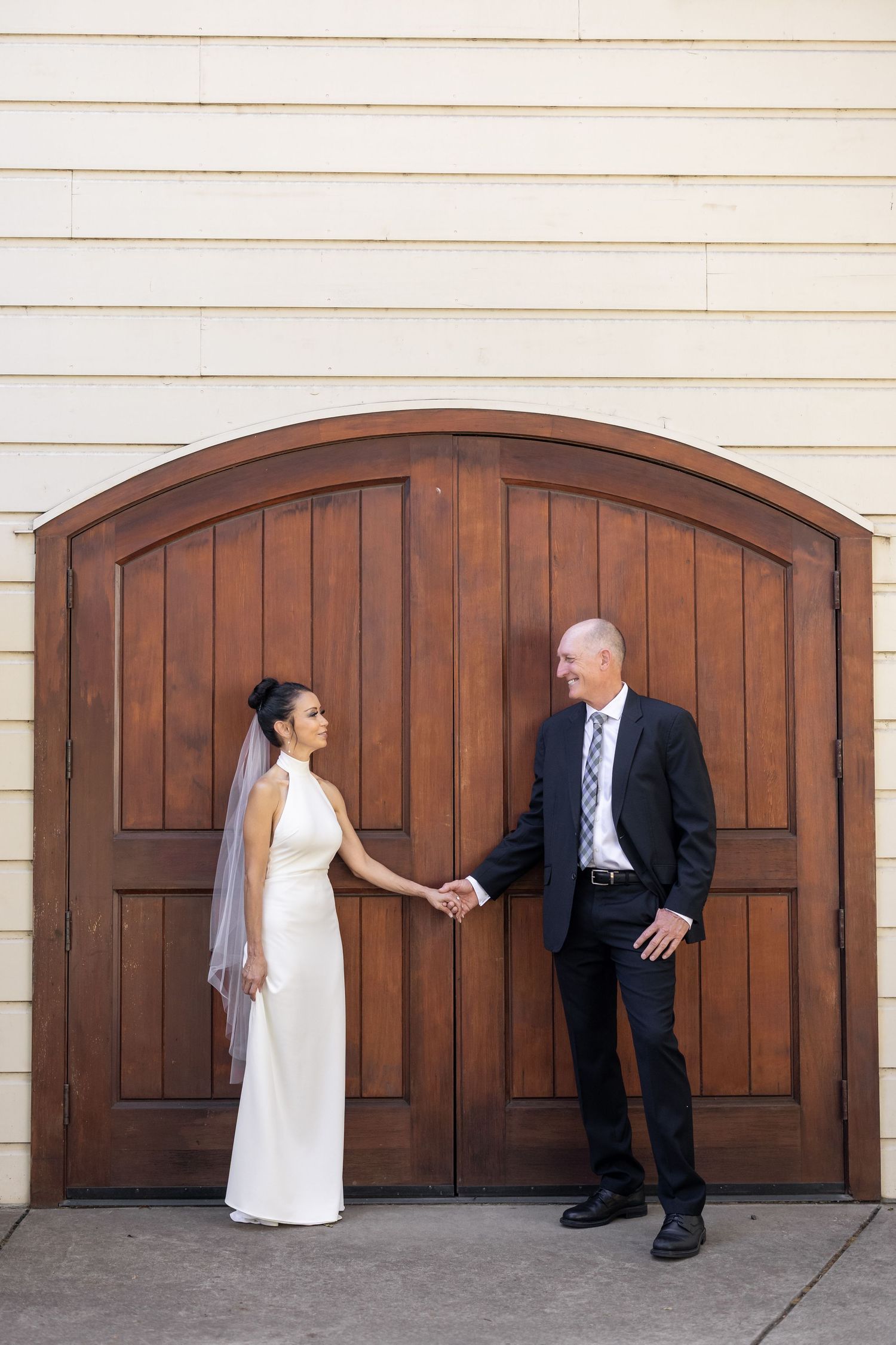 Playful wedding photo sequence against wooden garage doors showing couple's fun interaction.