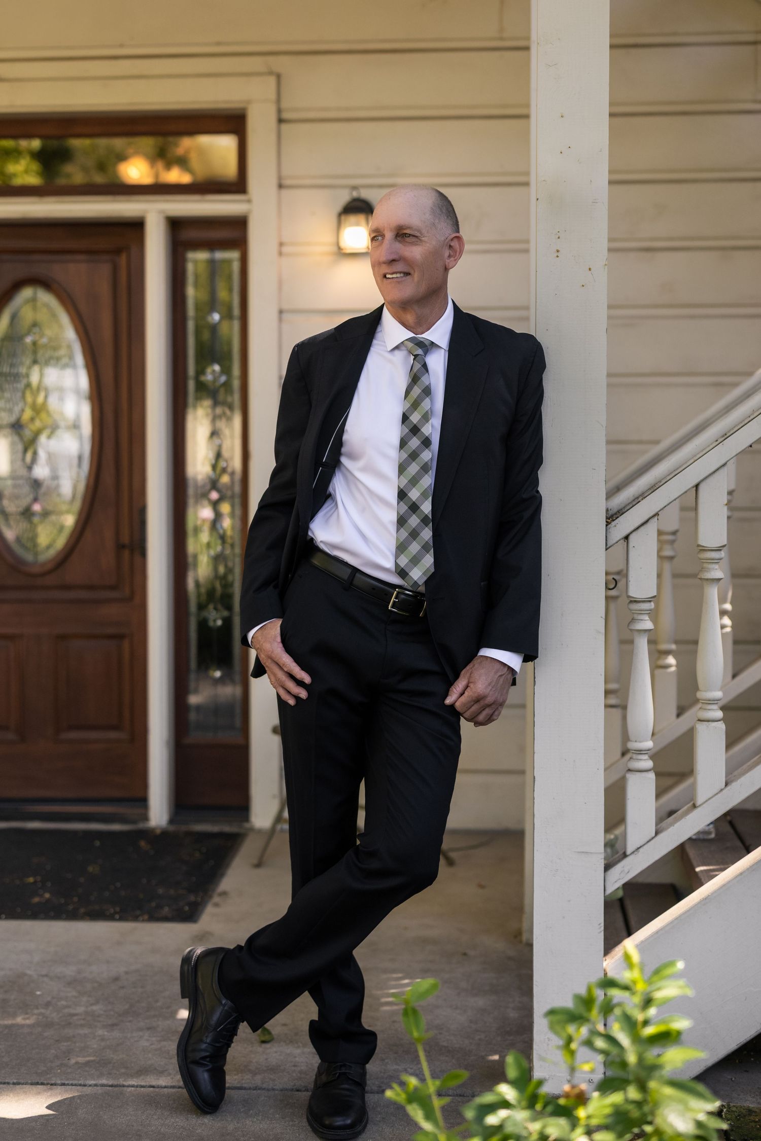 A playful series of poses against a white porch column wearing formal attire.