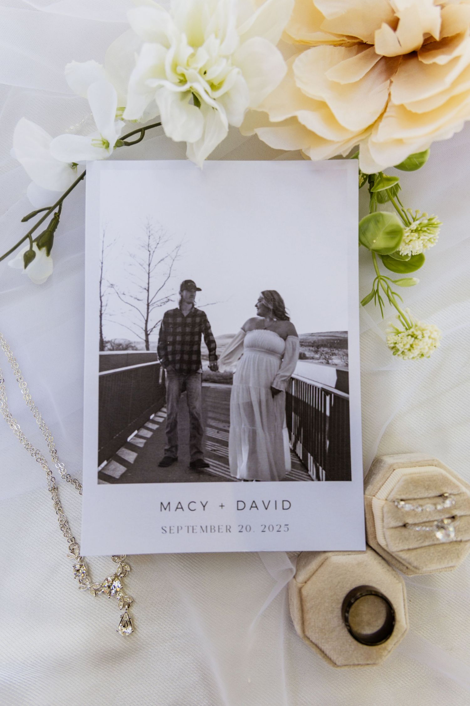 Wedding photo display with flowers, jewelry and a black and white portrait.