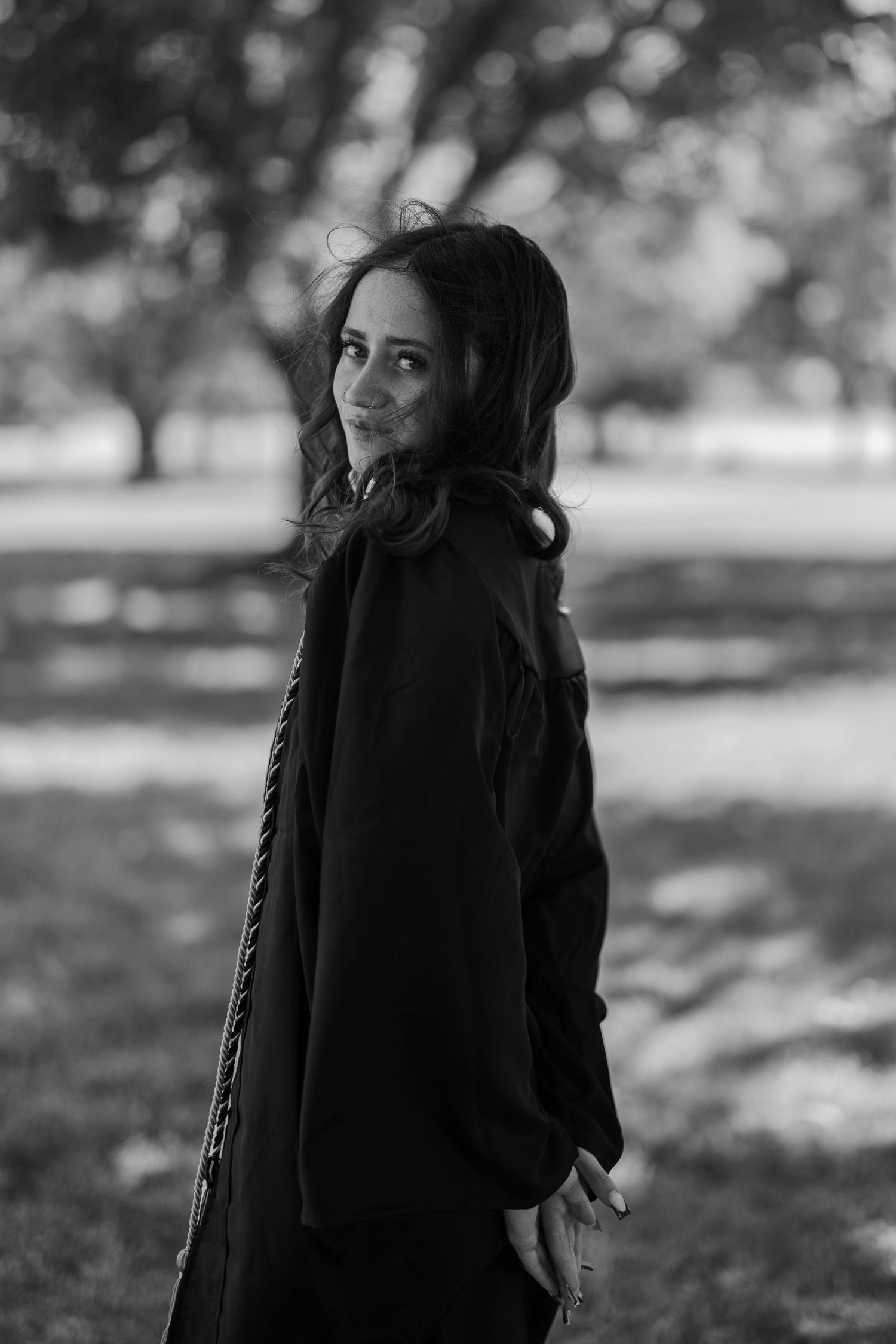Black and white portrait series showing playful expressions in an outdoor setting.
