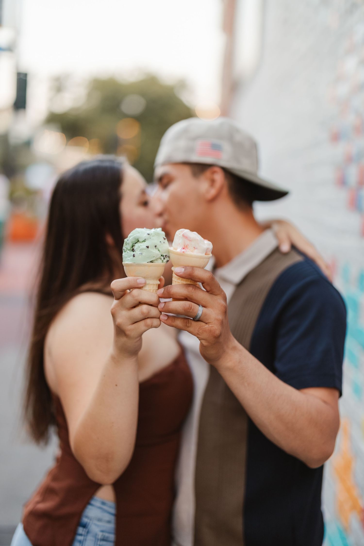 A couple sharing ice cream cones together during a romantic outdoor moment.