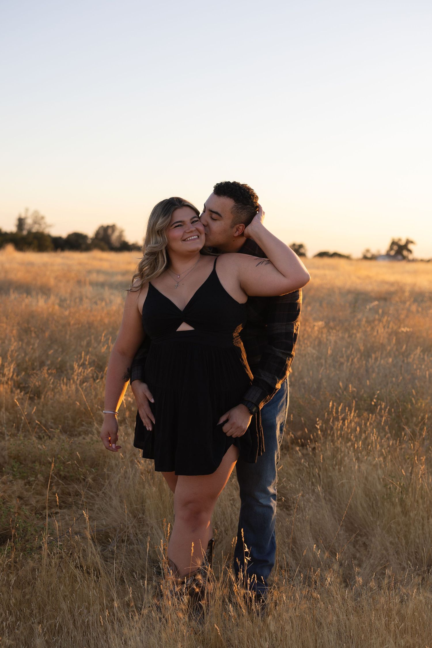 Romantic sunset photos in a golden field showing playful interactions.