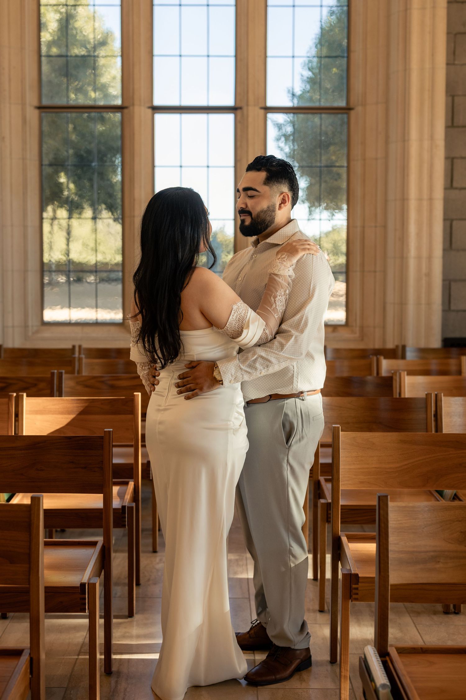 Romantic sequence inside a sunlit chapel with wooden pews creating a warm atmosphere.