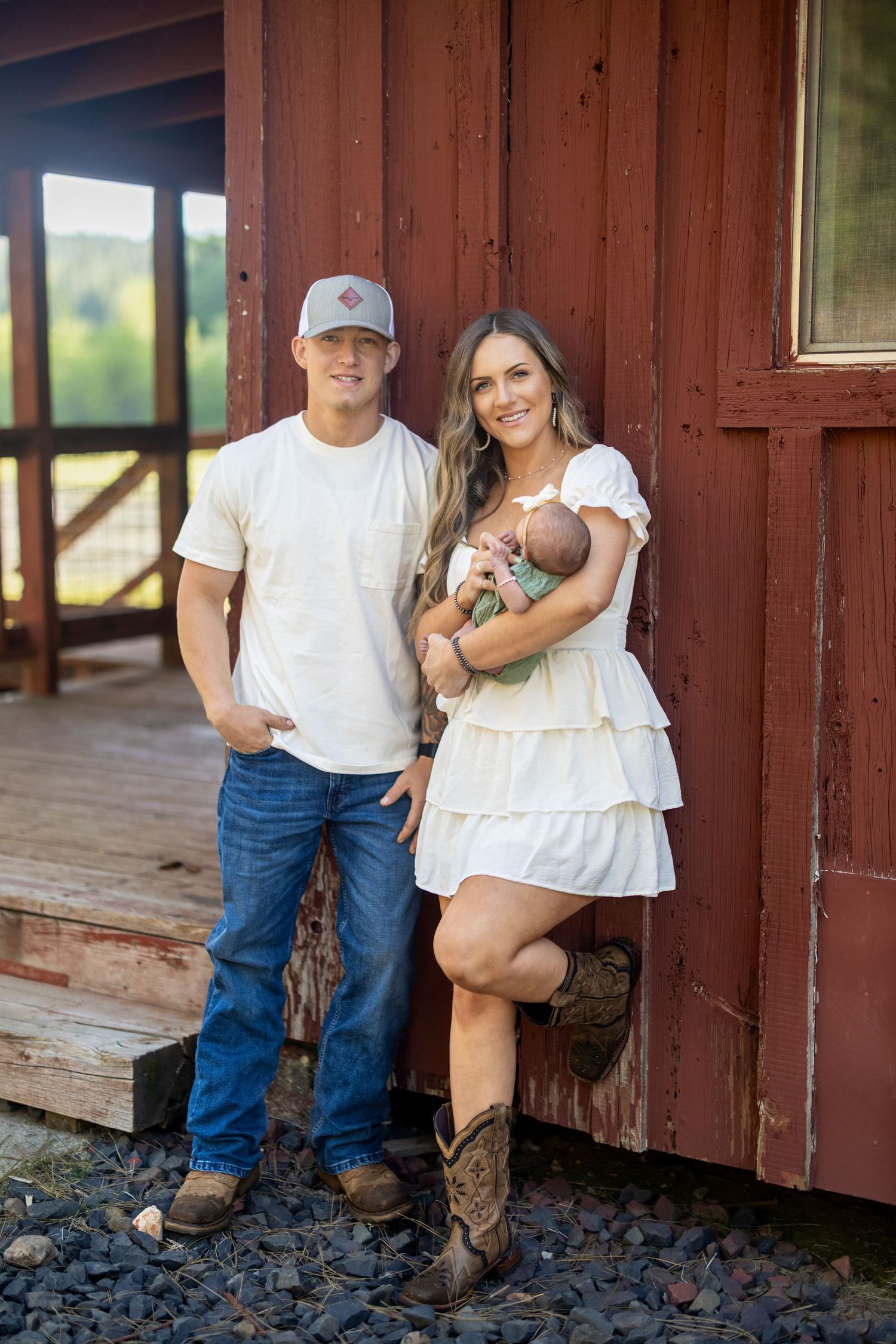 A rustic photoshoot against a red wooden train car backdrop.