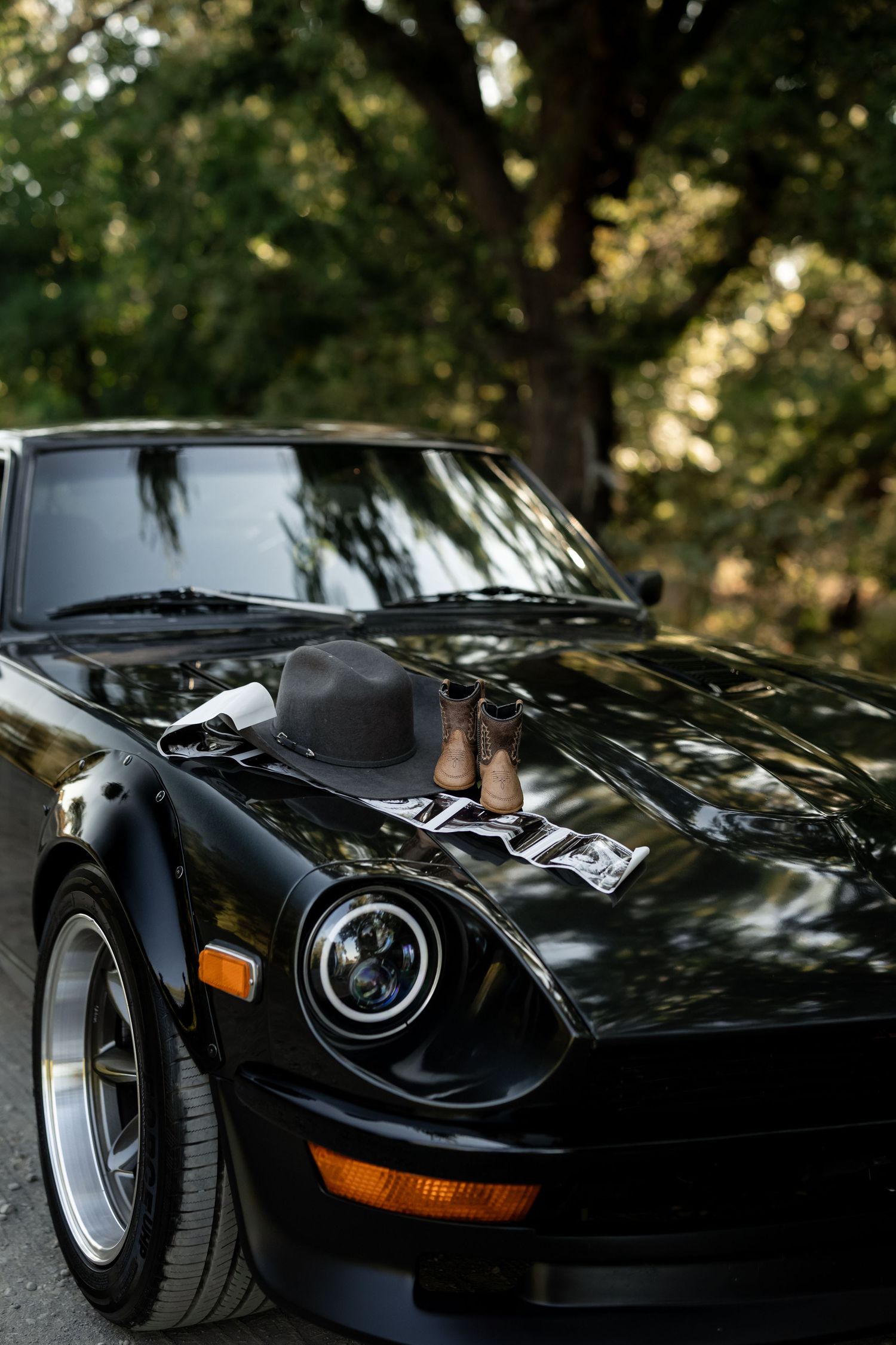 Close-up details of a sleek black vintage sports car with retro headlights.