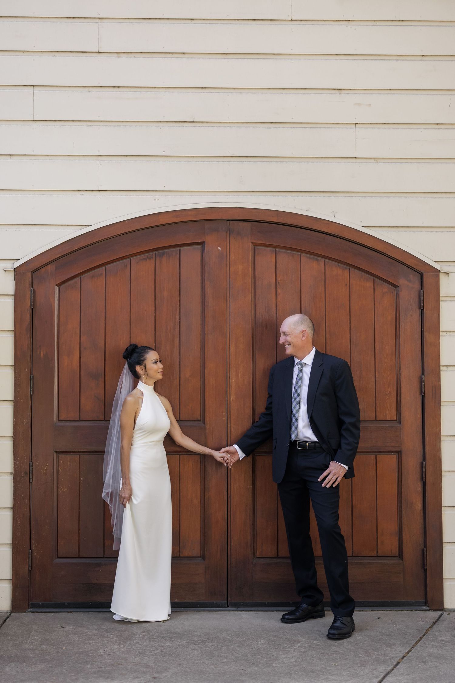 Playful wedding photo sequence showing couple posing against wooden garage doors.
