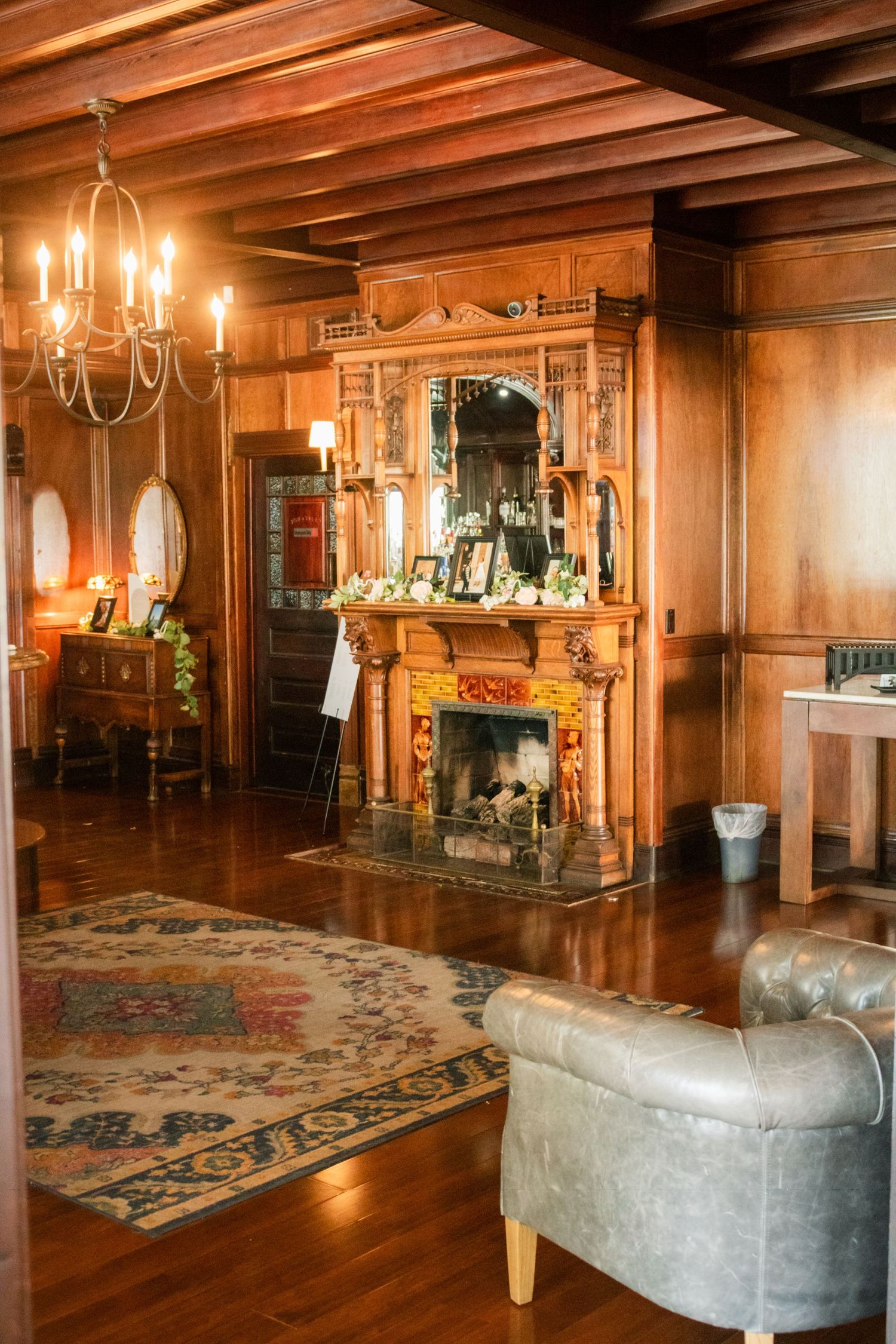 Elegant vintage interior with ornate wooden fireplace, chandelier and oriental rug.